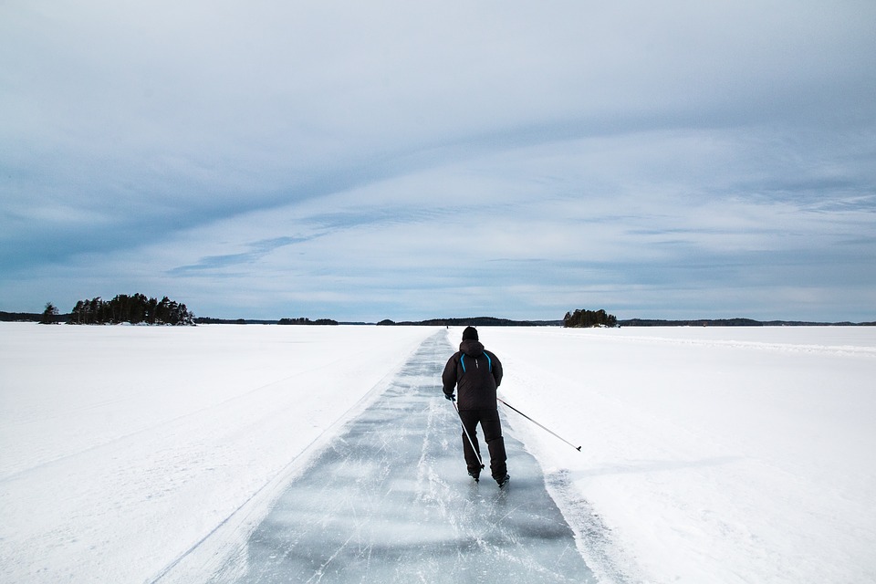 A person cross country skiing across a frozen lake