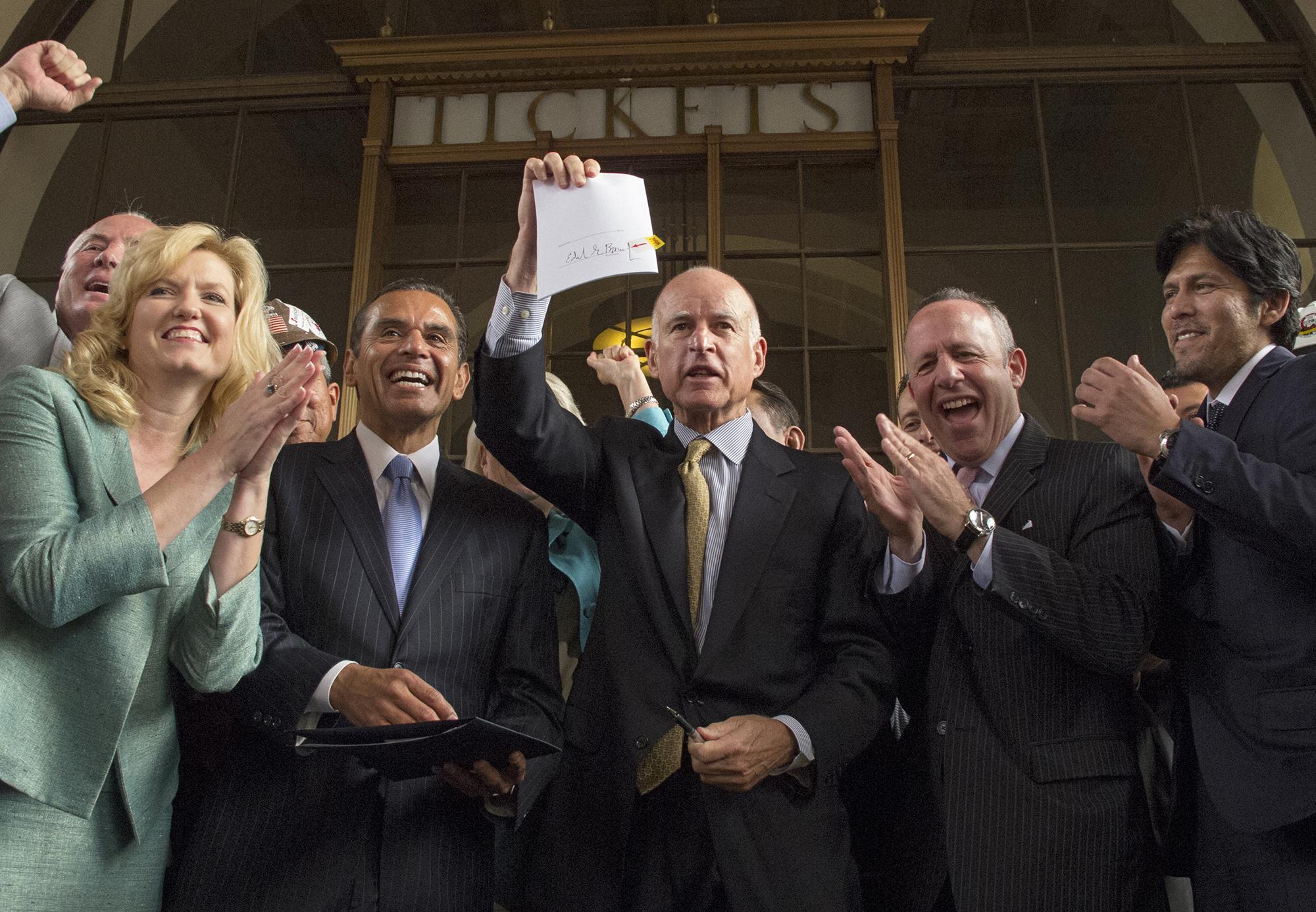 California Gov. Jerry Brown displays legislation authorizing California's high-speed rail line