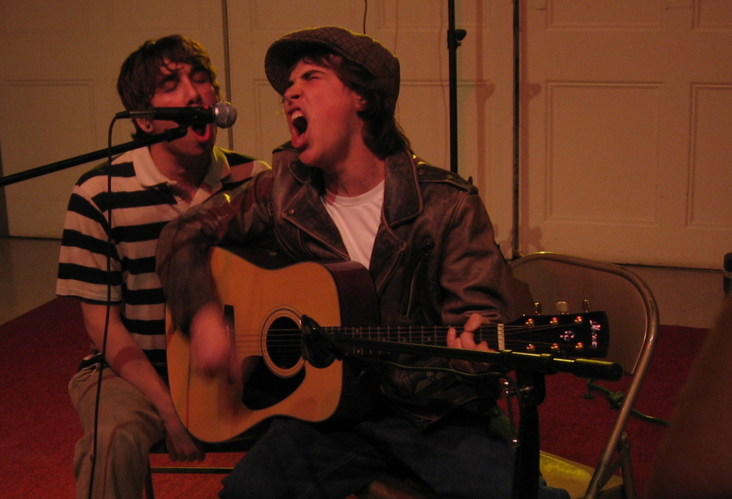 Two men singing into a microphone