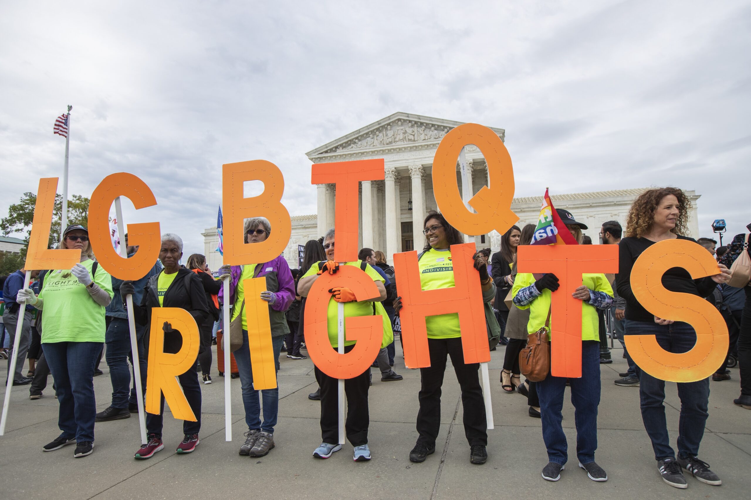 Supporters of LGBTQ rights hold placards in front of the U.S. Supreme Court