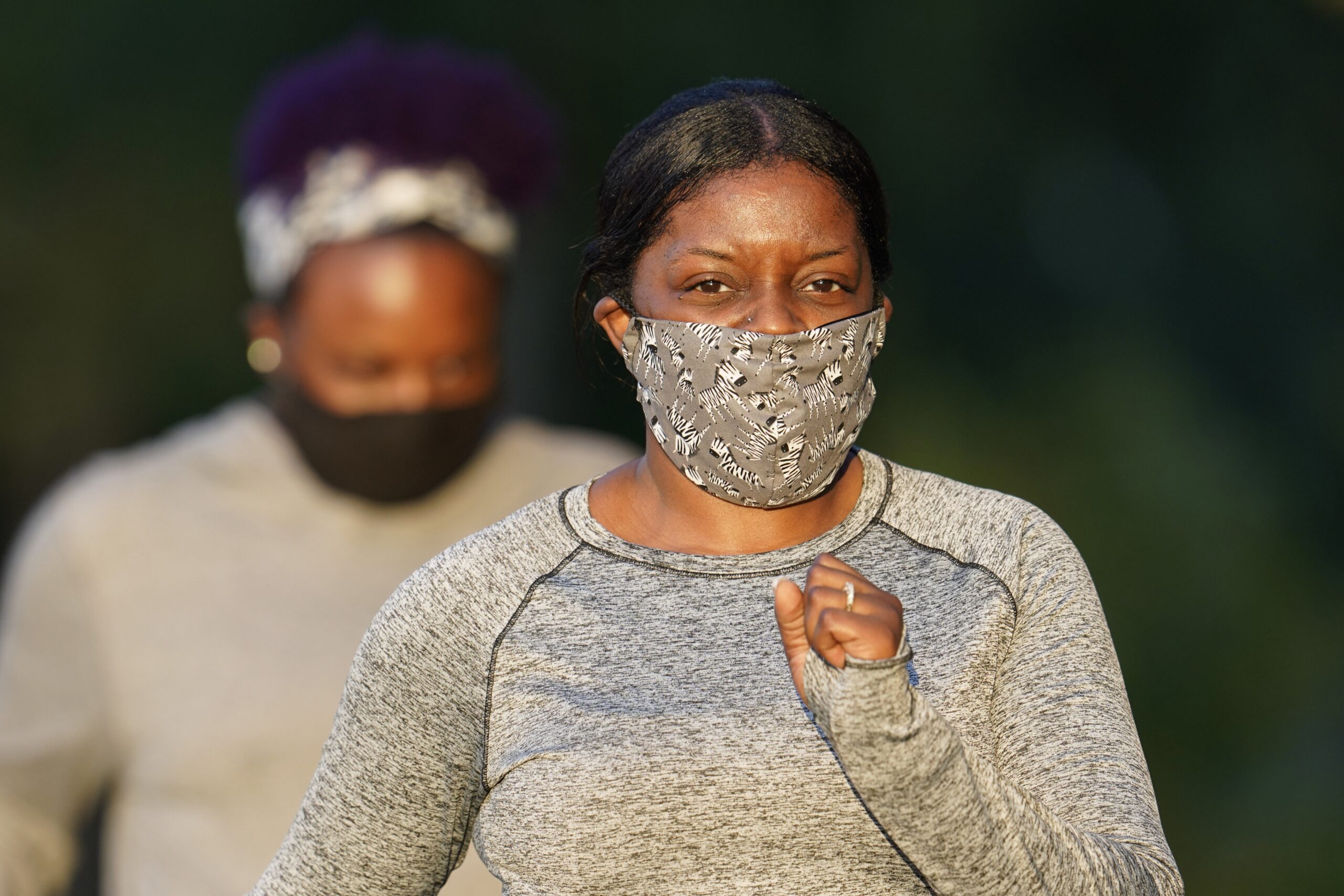 Kedria Grigsby walks along a park trail while wearing a face mask to help prevent the spread of COVID-19