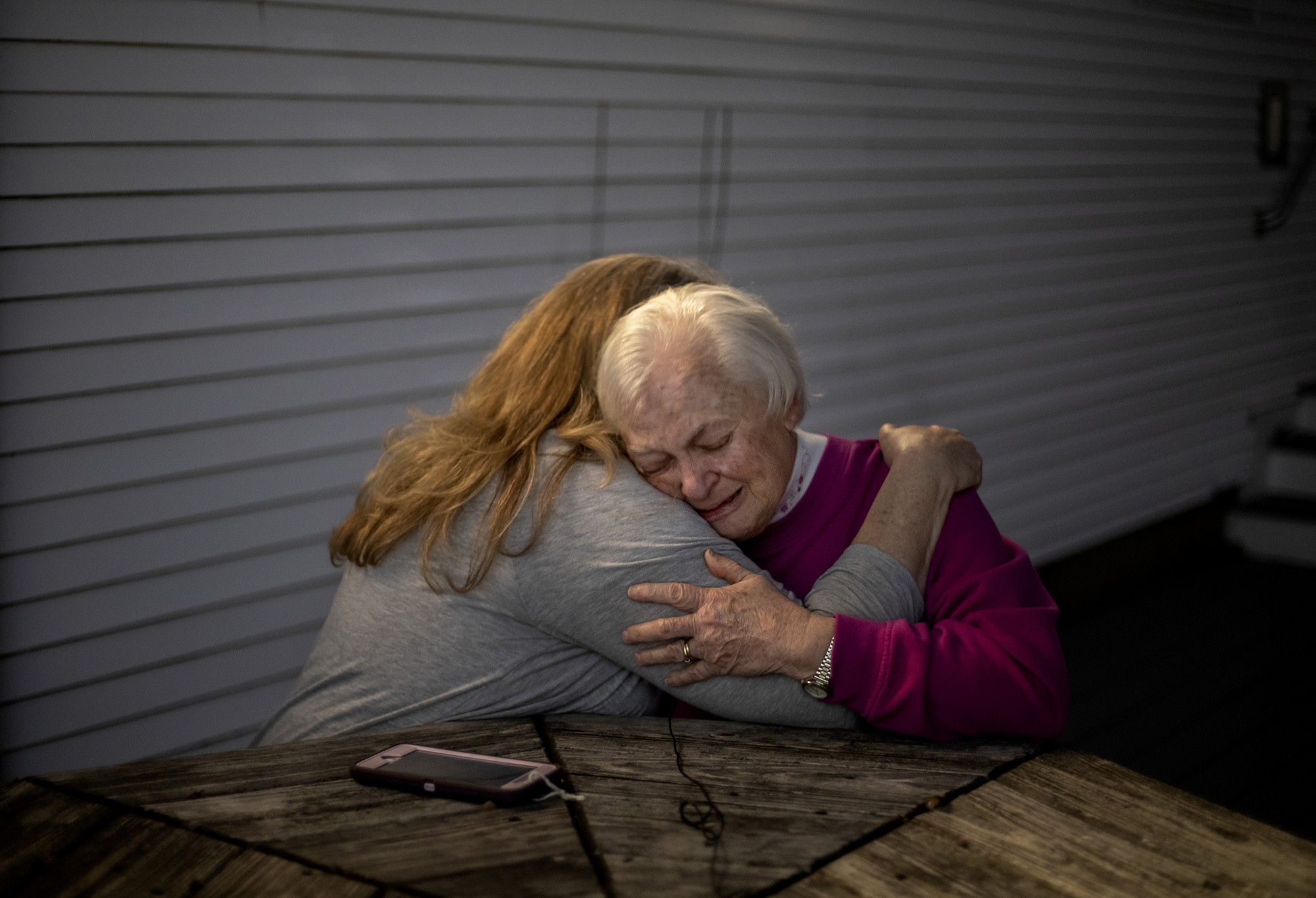 Alice Lowell the wife of veteran Charles Lowell who died of the COVID-19 virus, is embraced by her daughter