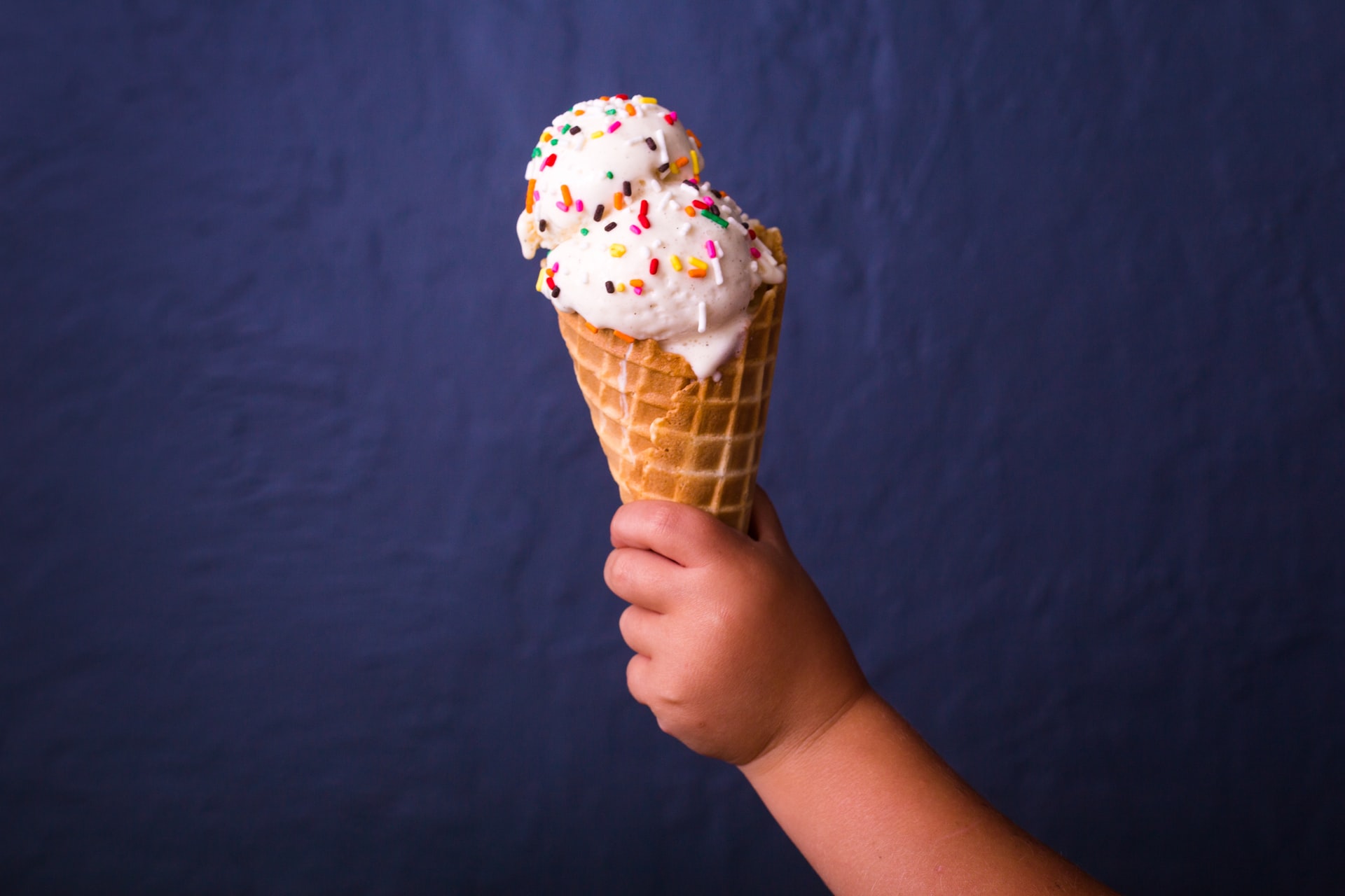 A baby holds an ice cream cone