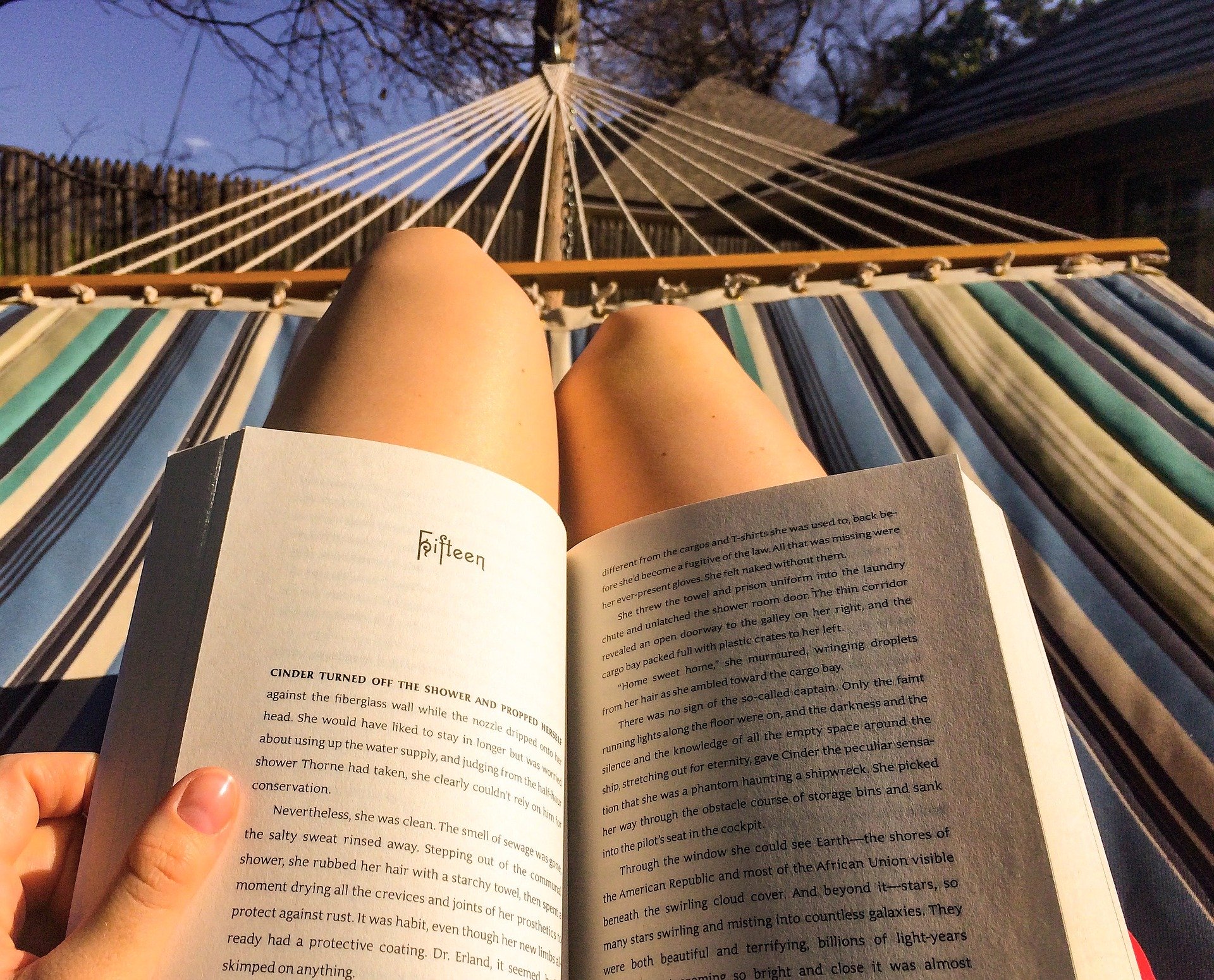 Reading a book in a hammock.