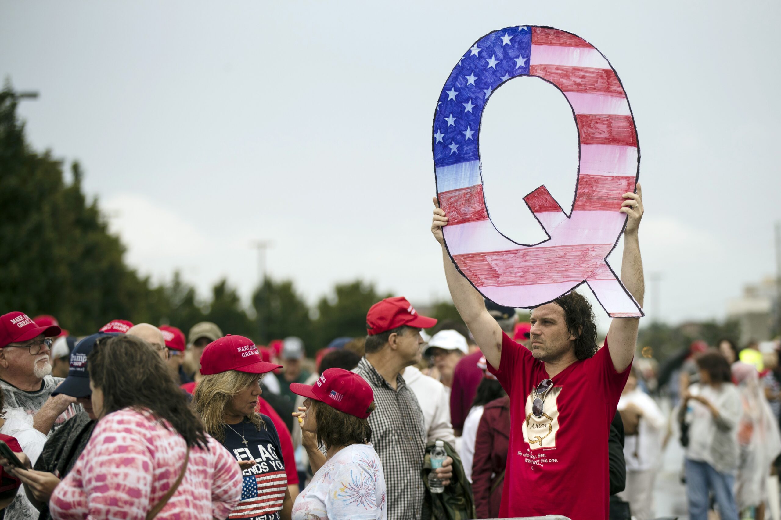 A man holding a Q sign at a Donald Trump rally