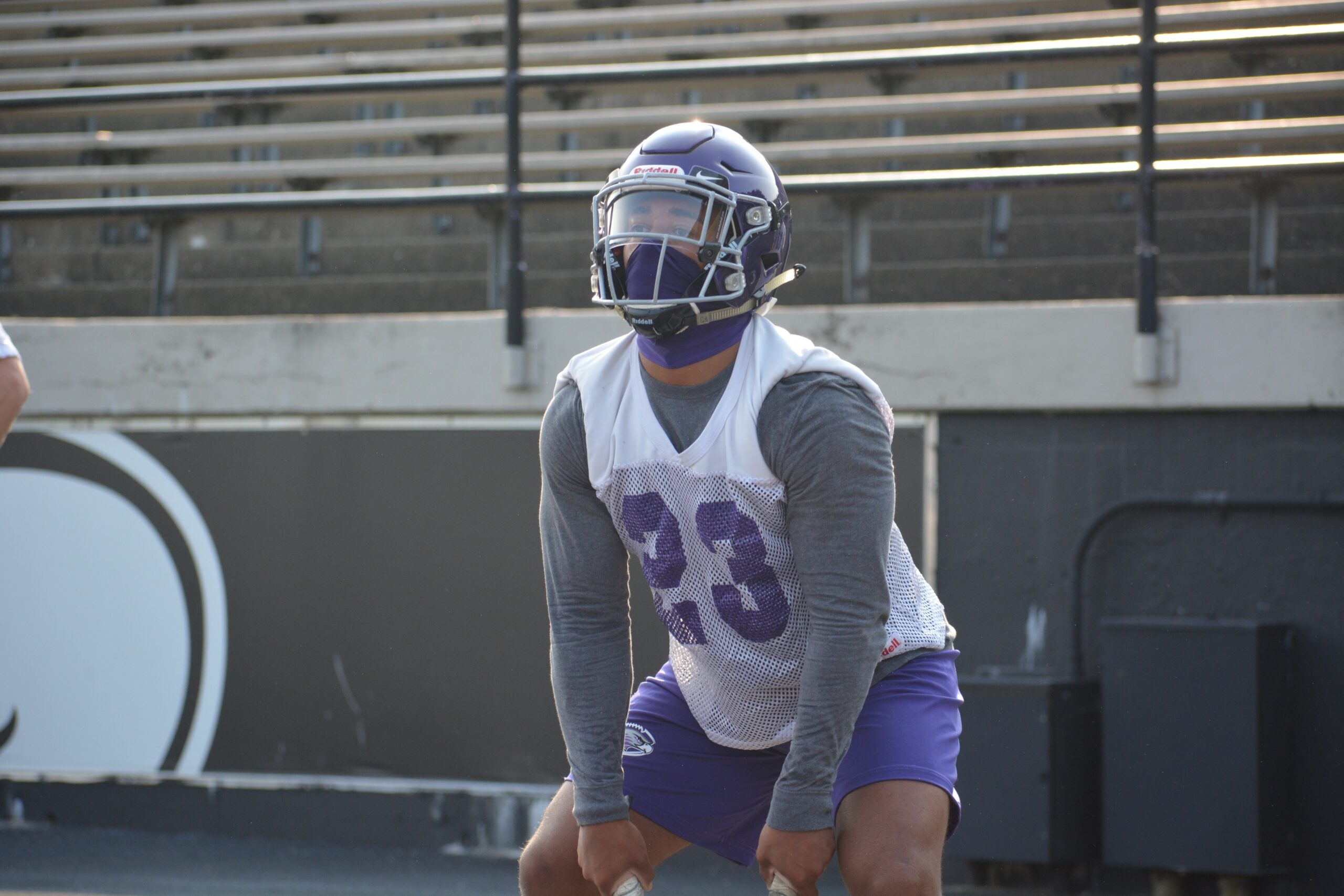 Warhawk football player squatting during practice