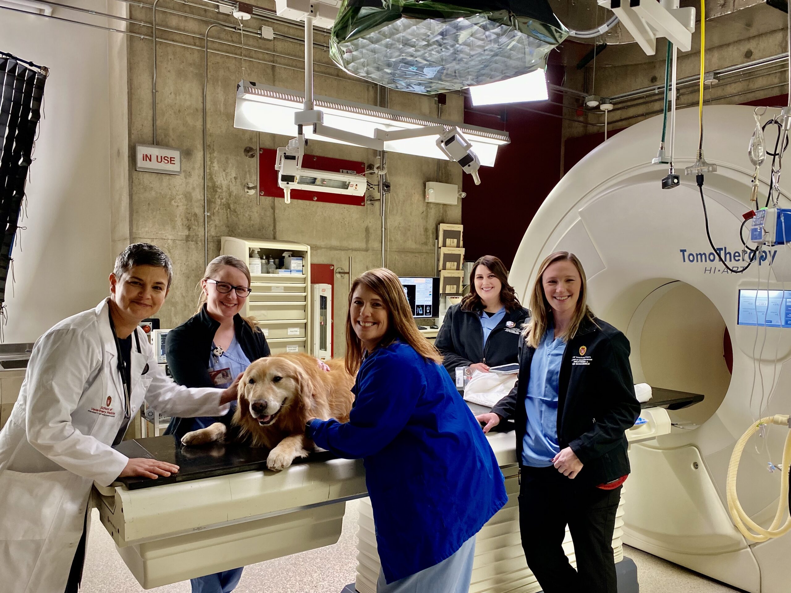 Scout poses with members of the UW Veterinary Care team