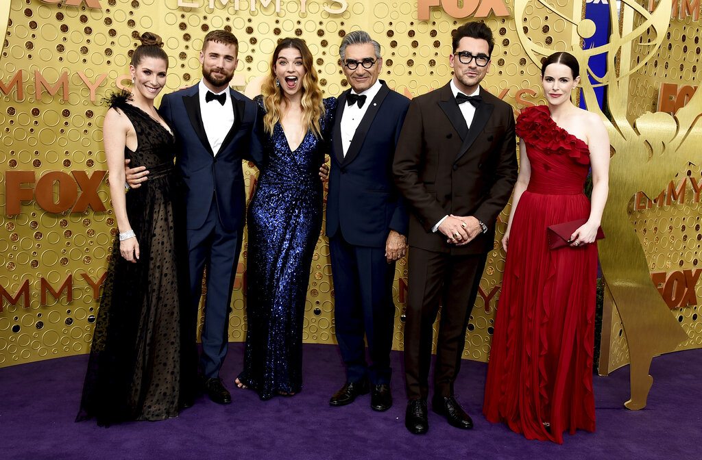 The cast of Schitt's Creek stand for a photo in formal wear.