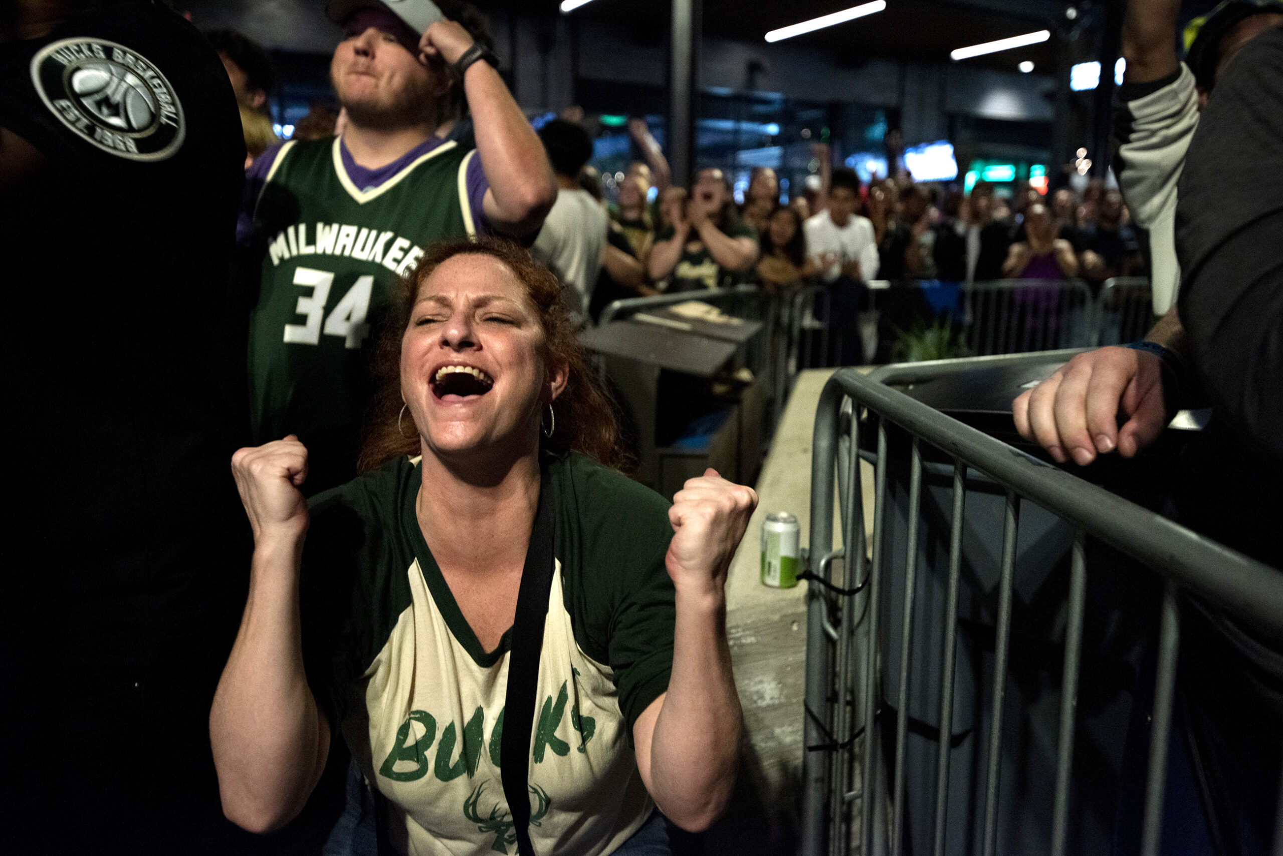 A fan makes fists as she expresses relief at the end of the Bucks game.