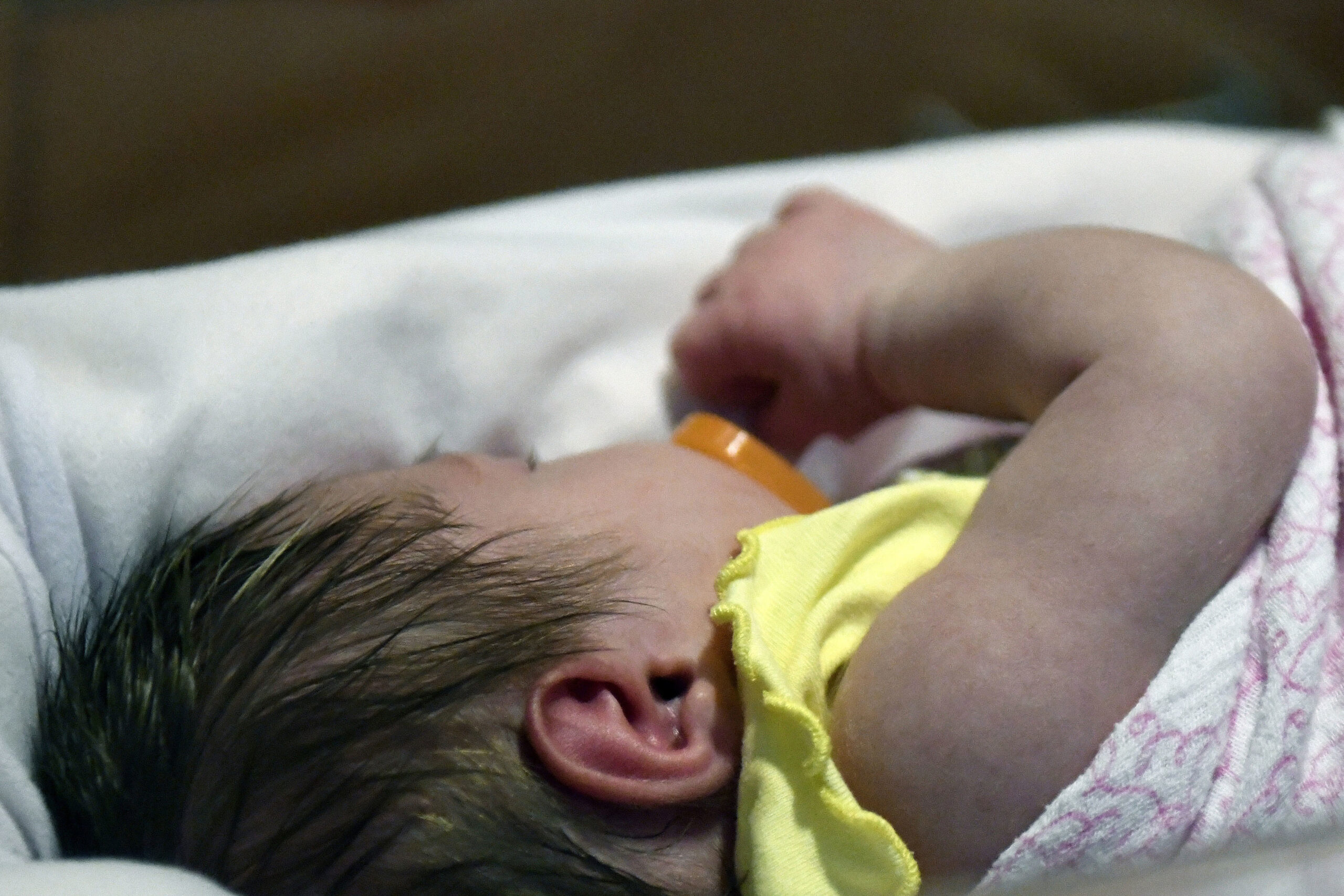 A week-old baby lies in a neonatal intensive care unit