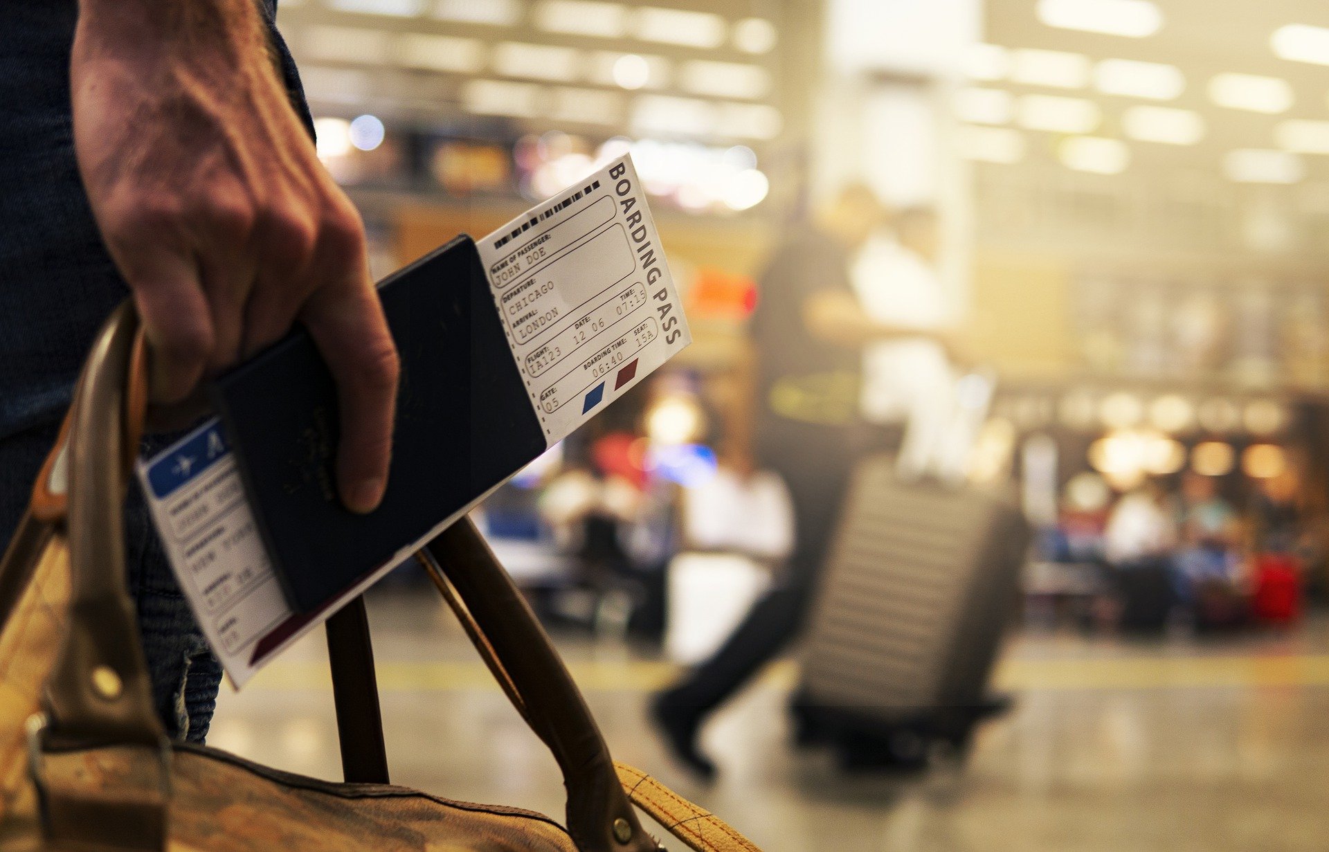 Traveler holding passport and boarding pass in airport.