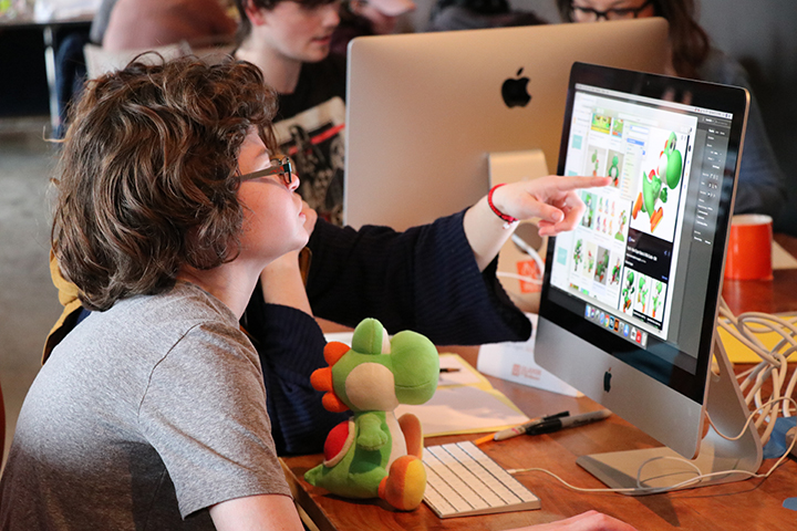 A student with autism looks at a computer screen with photos of the Nintendo character Yoshi
