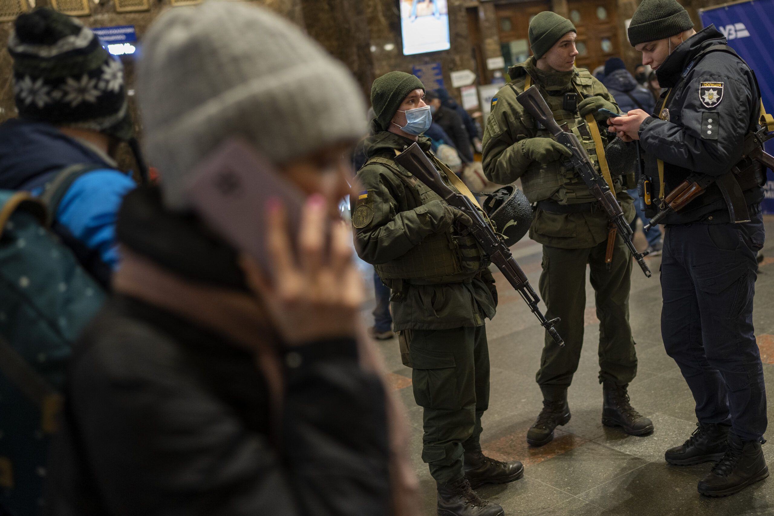 Ukrainian soldiers stand guard as people try to leave at the Kyiv train station