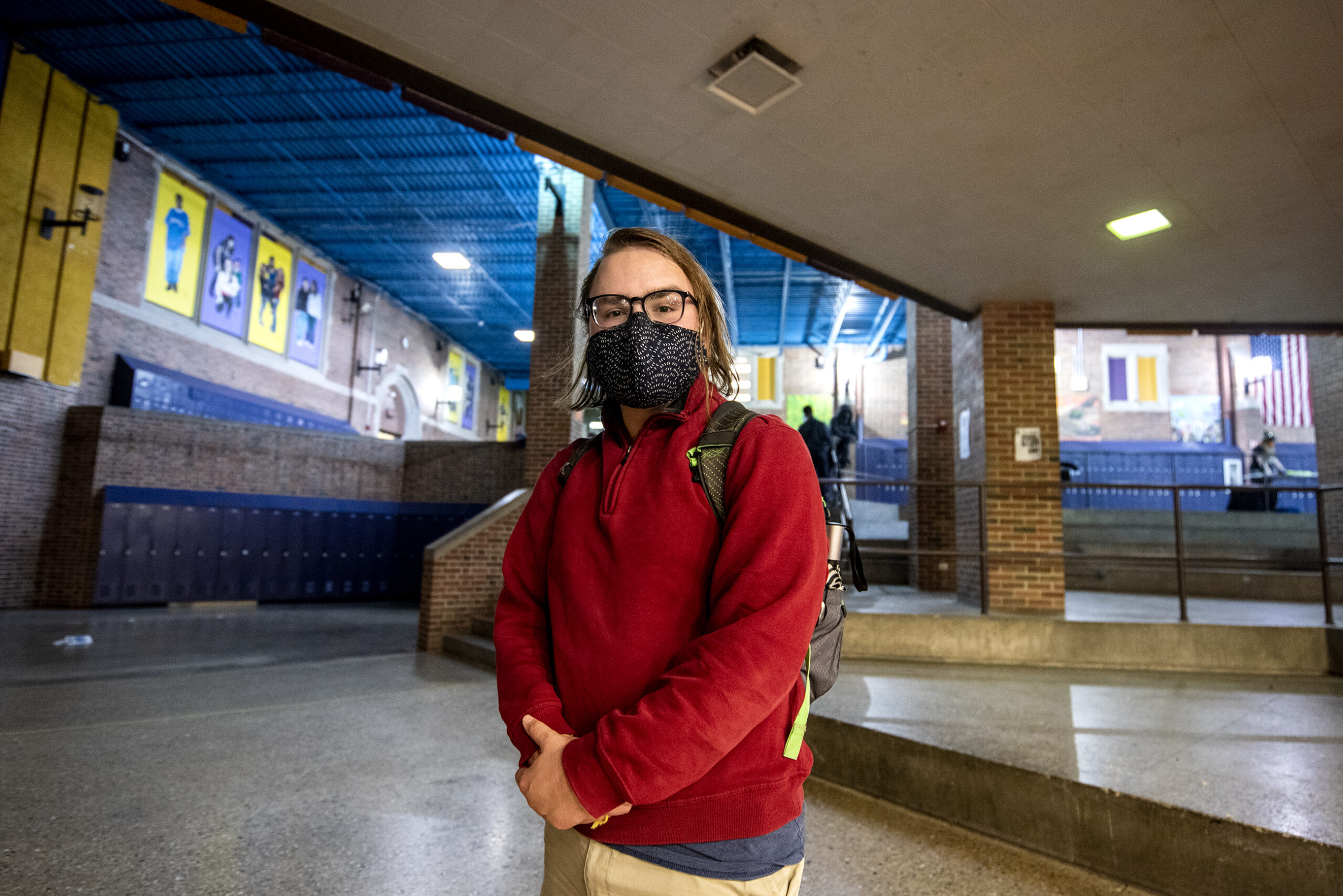 A student stands inside of Madison East High School.