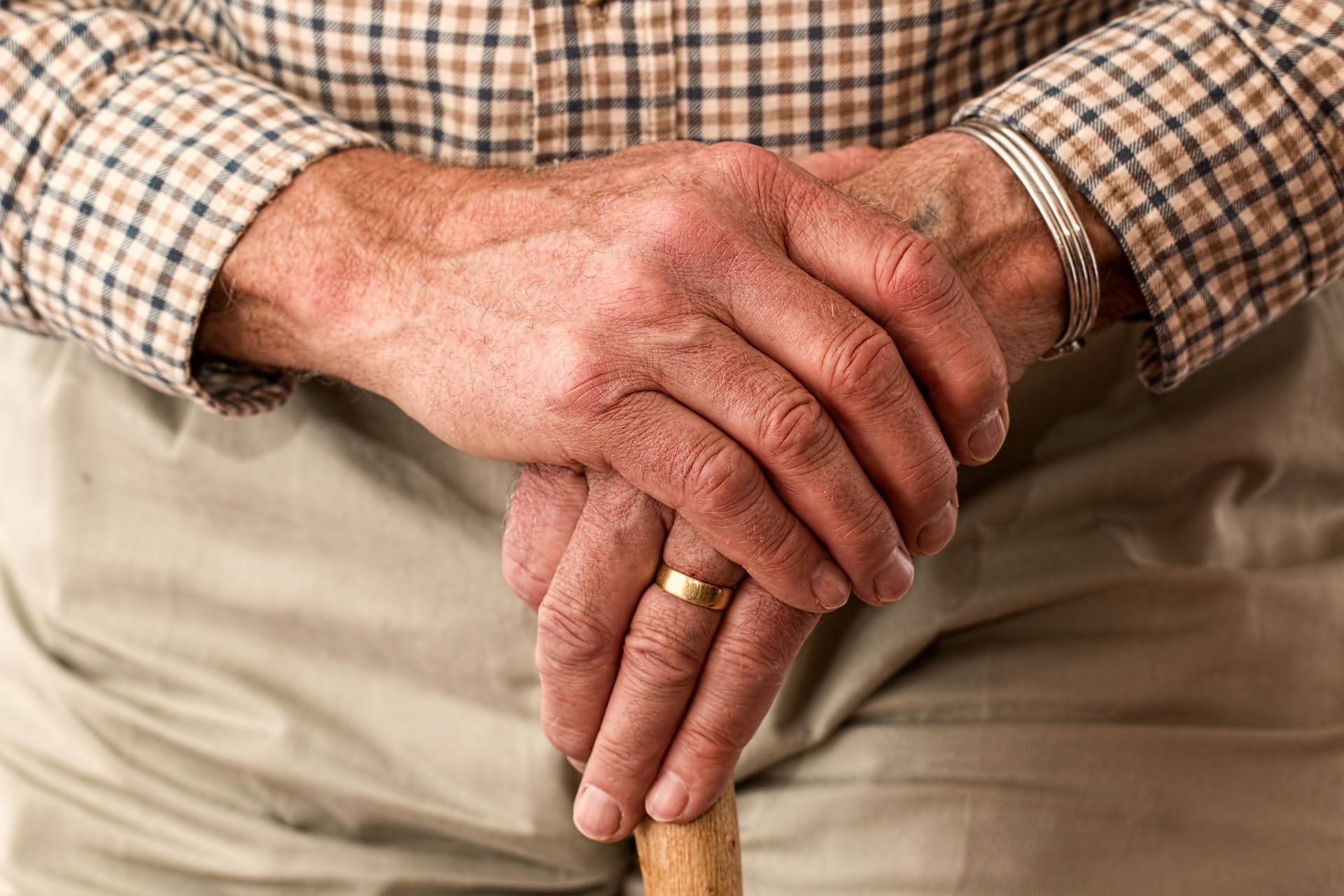 Elderly hands on cane