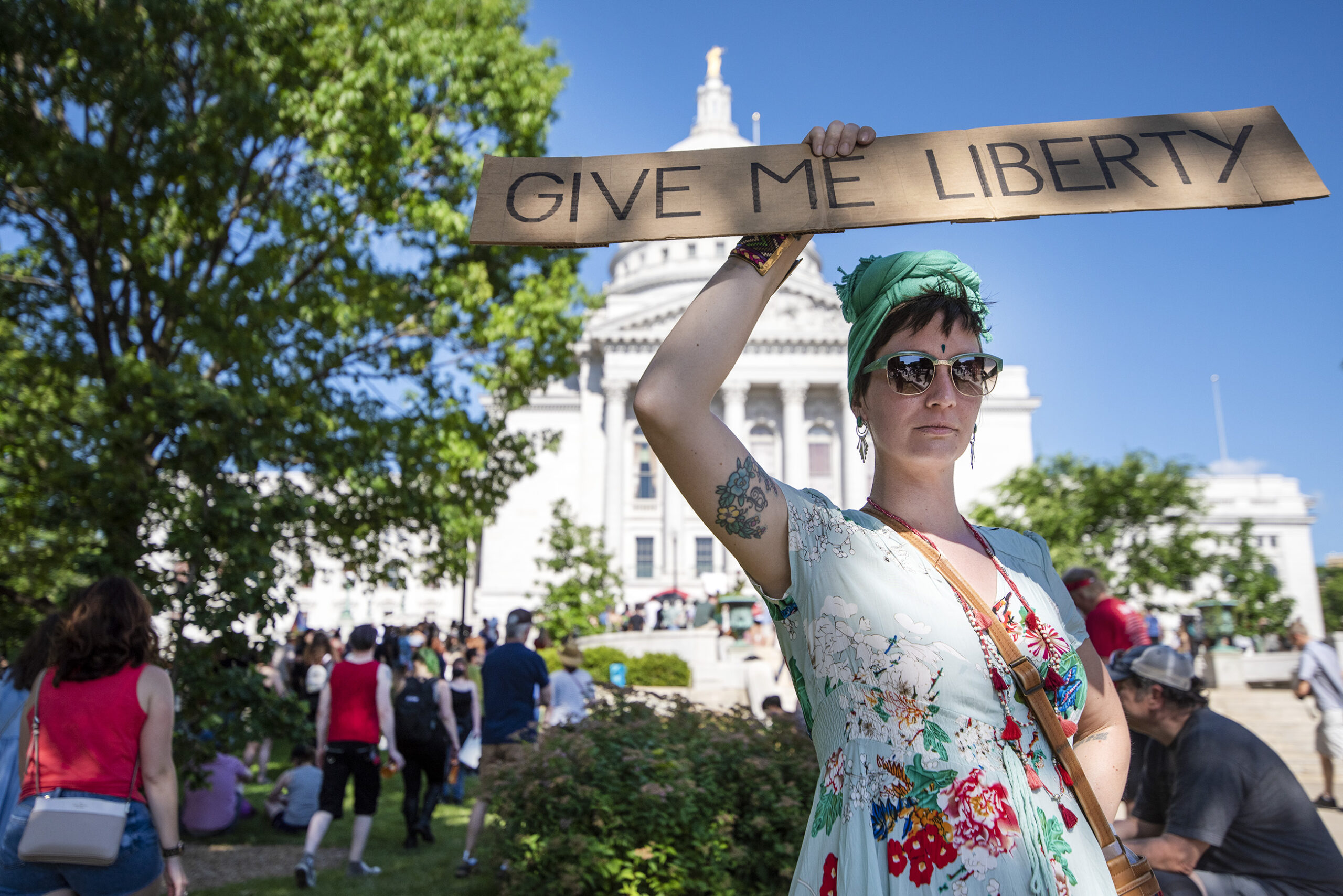A protester's sign says "give me liberty."