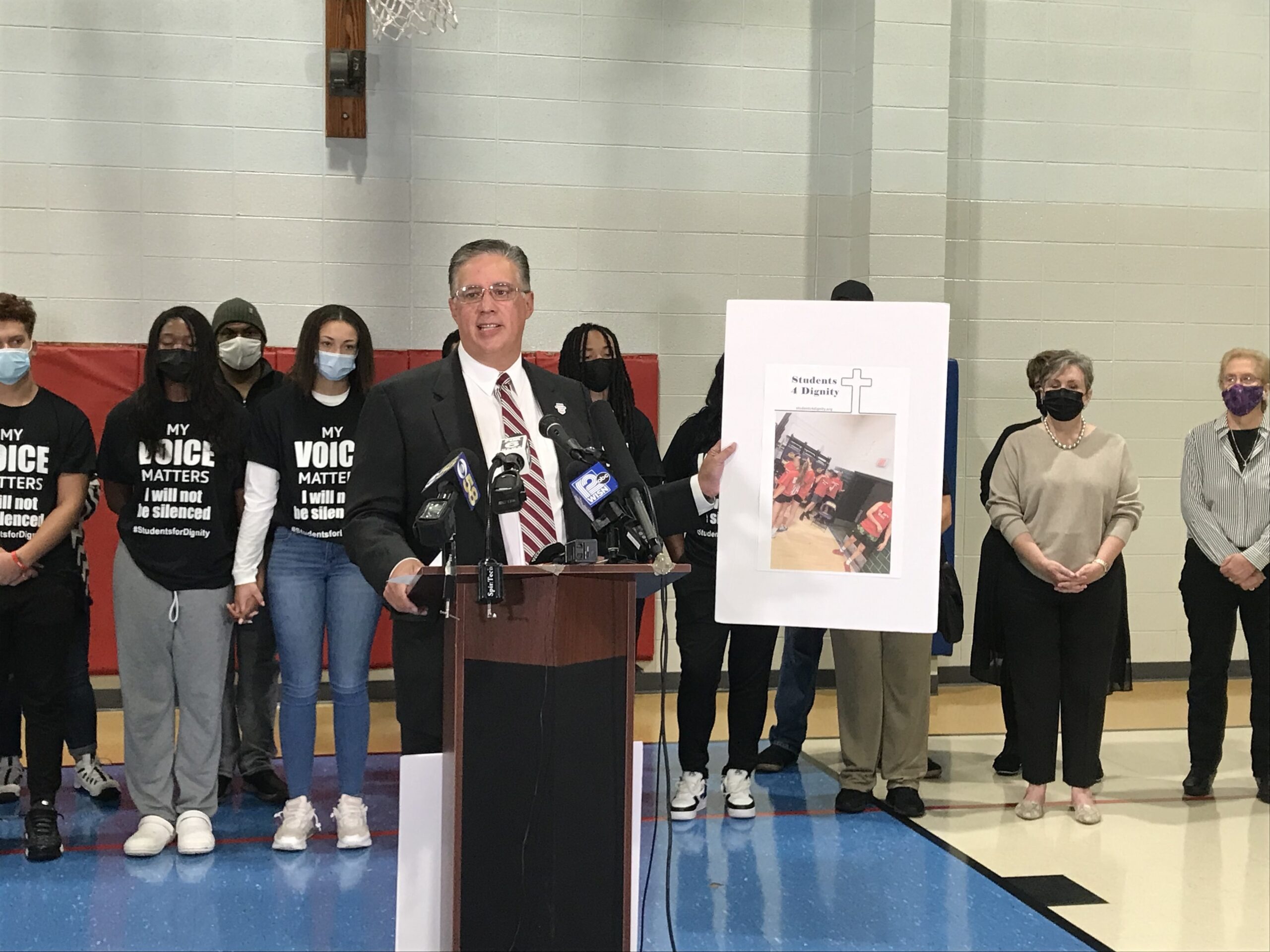 Forward Latino national president Darryl Morin holds up a photo of Racine Lutheran High School students wearing "Build the Wall" t-shirts as he describes incidents of racial harassment directed at Black and Latino students at the school.