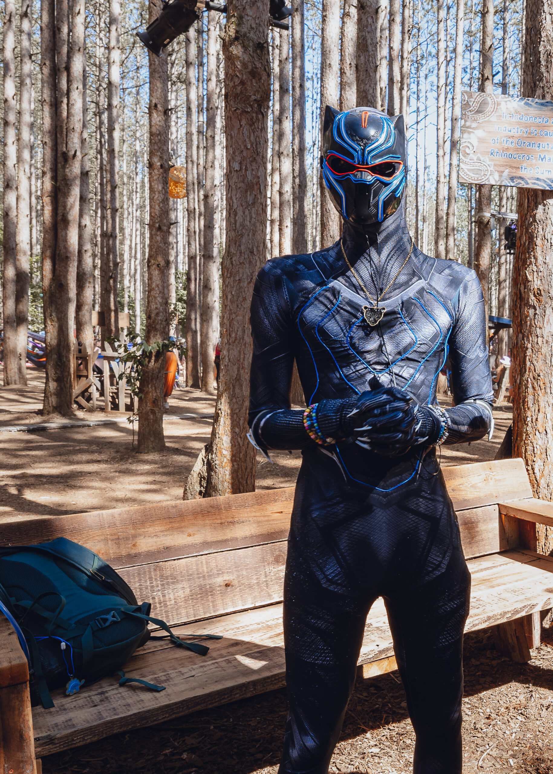 Photo of a man wearing a Black Panther costume, surrounded by trees