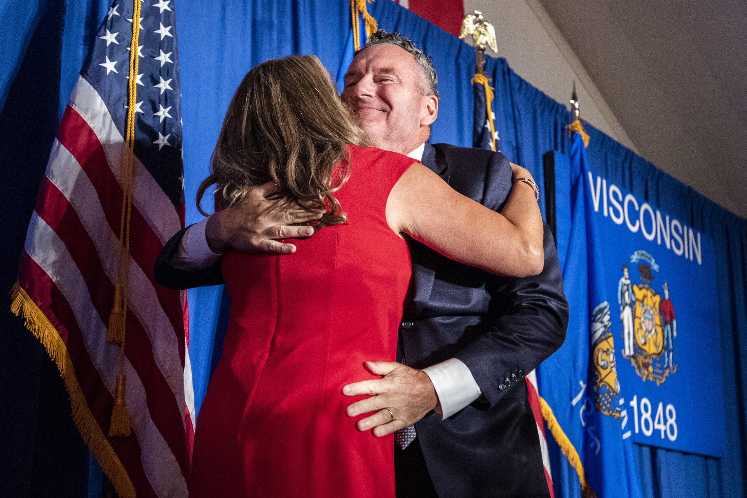 Tim Michels hugs his wife on stage at his event.