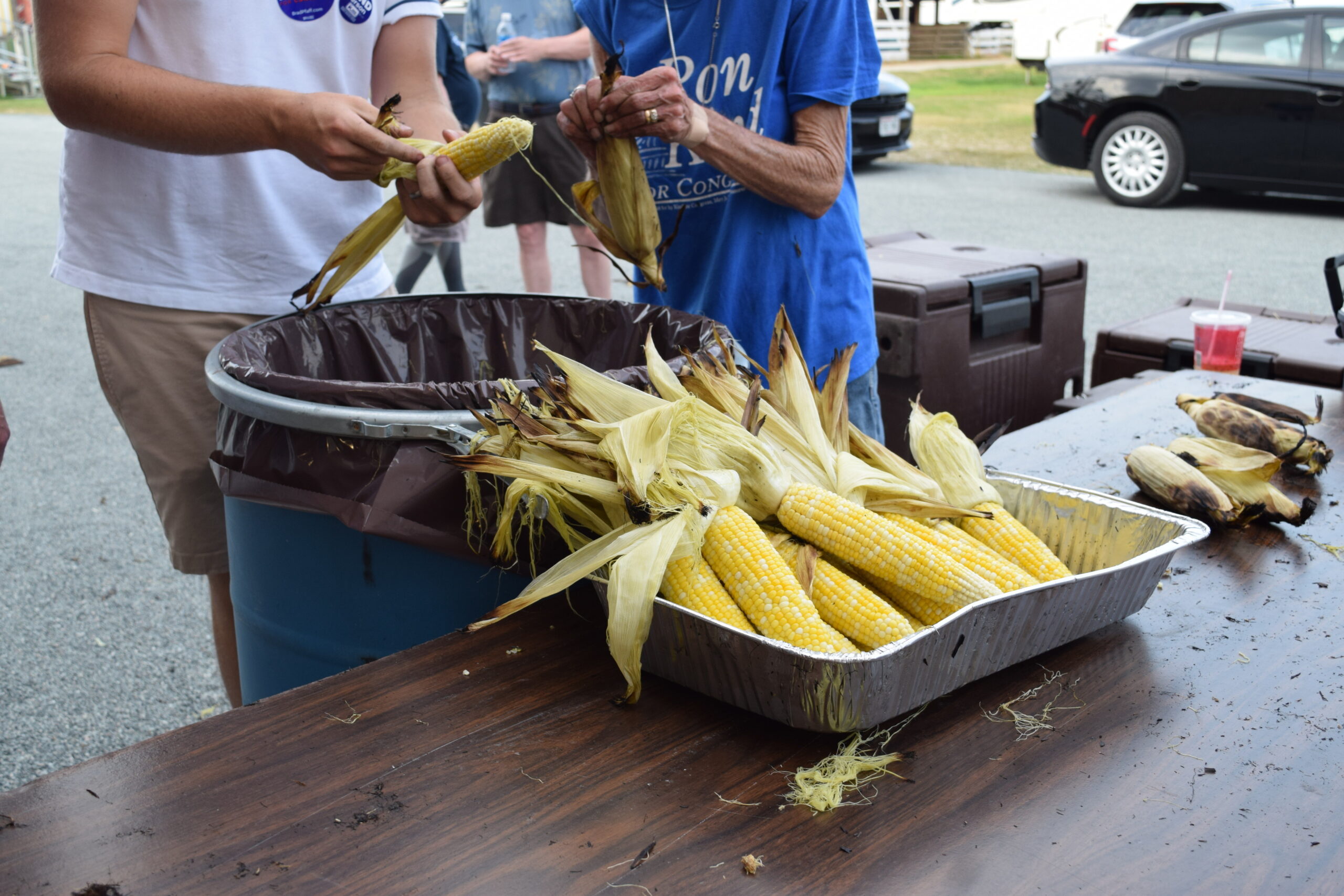 campaign volunteers shuck corn