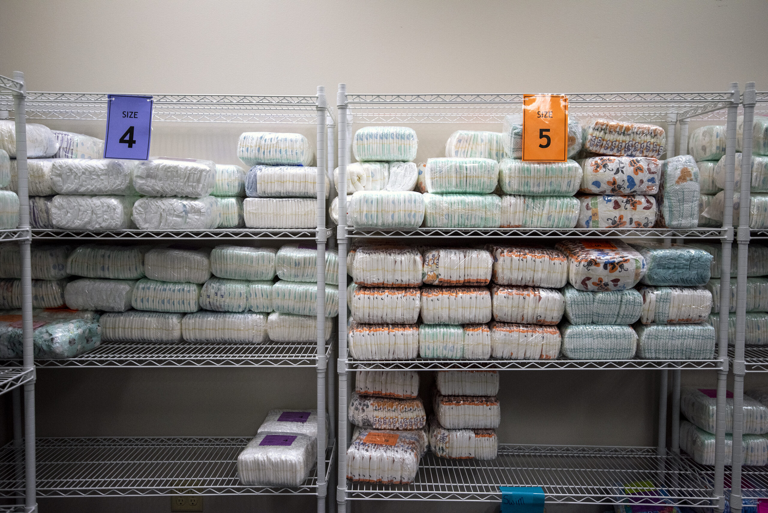 Packaged diapers are on a shelf.