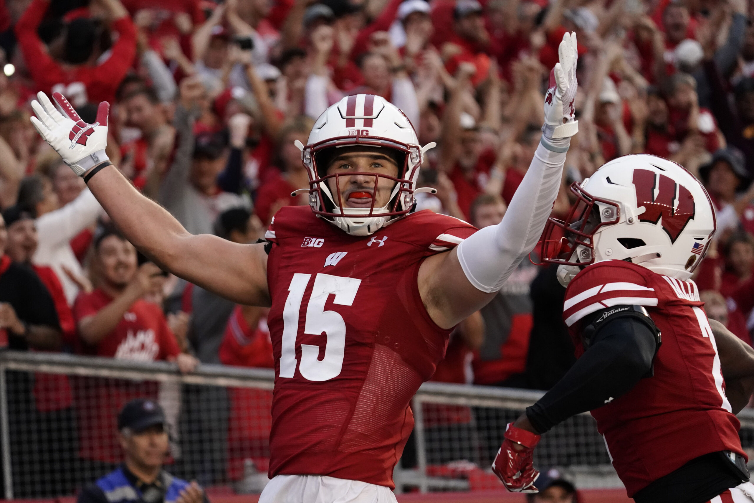 Wisconsin's John Torchio gestures to the crowd after running an interception back for a touchdown