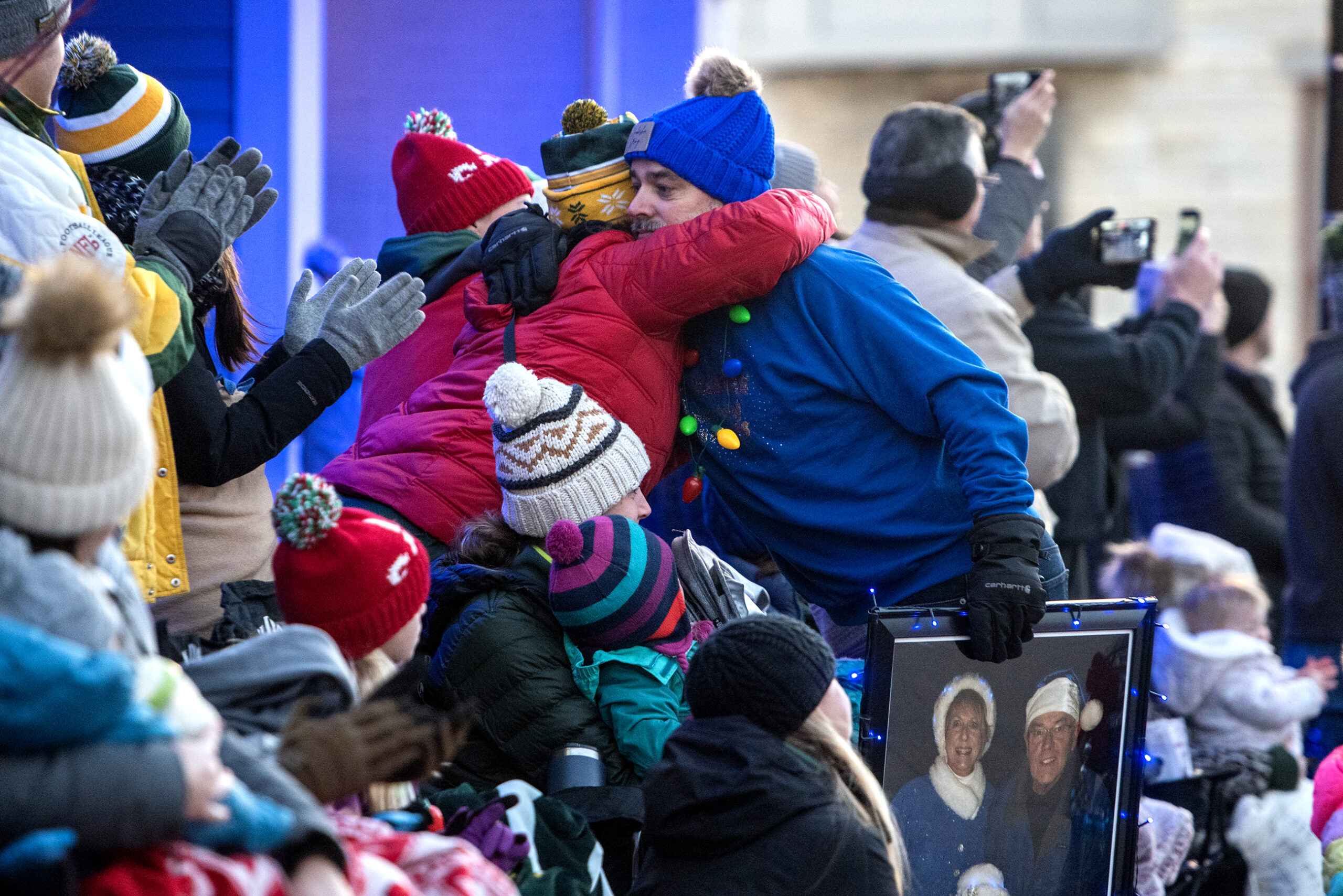 People hug in the crowd of parade attendees.