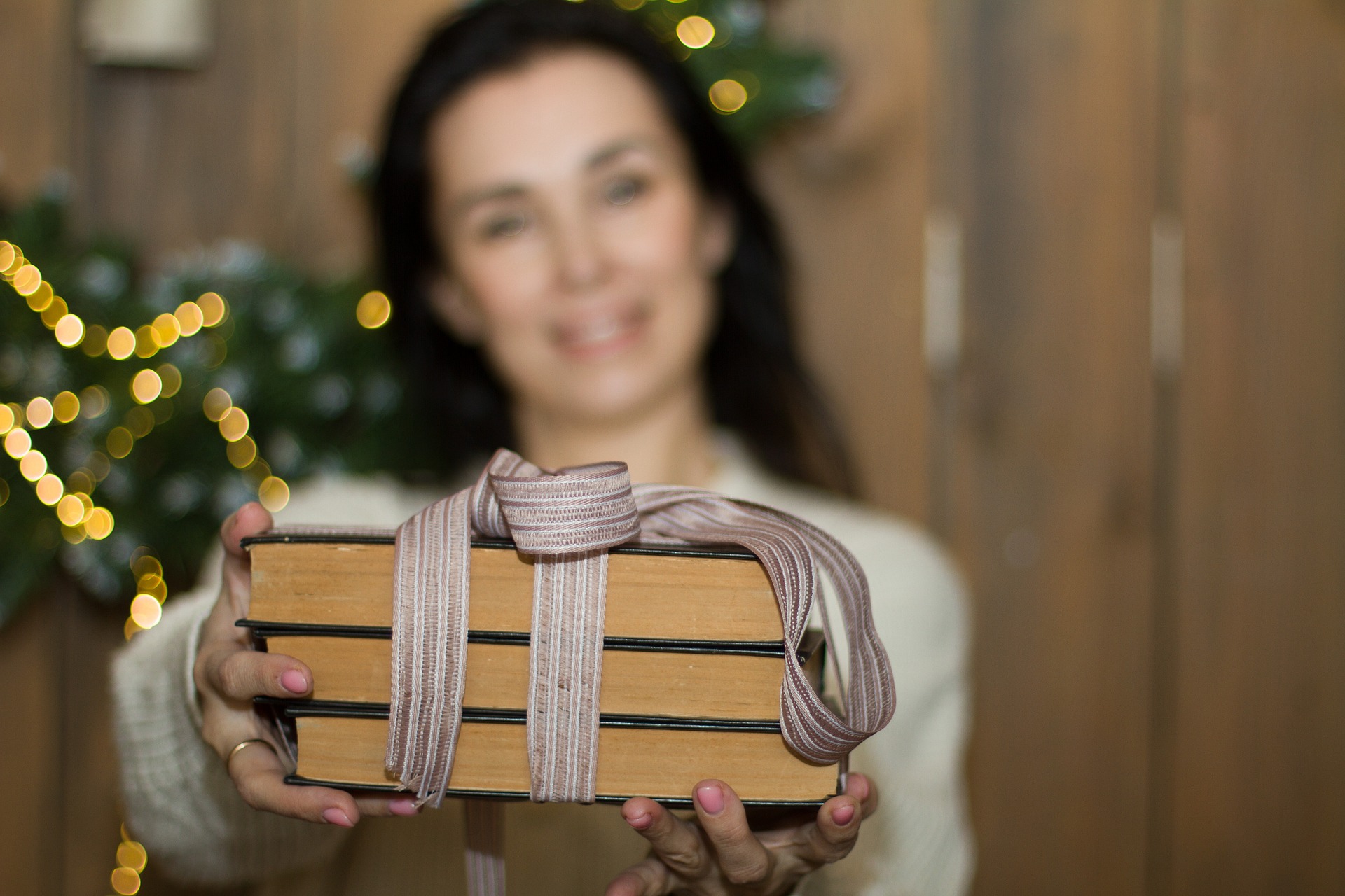 Woman holding books tied with a bow.