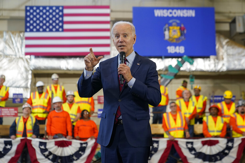 President Biden speaks in front of workers and flags of the state of Wisconsin and the United States