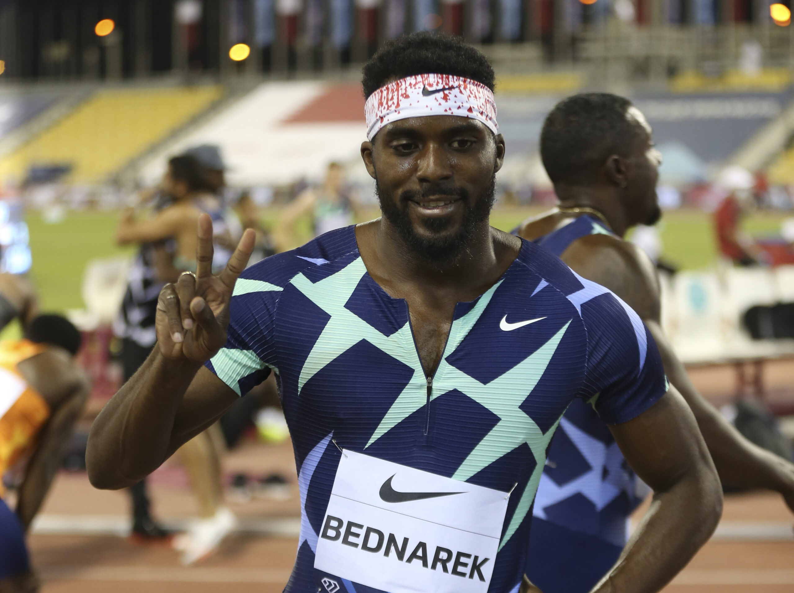 A man holds up two fingers celebrating a win in a track and field race