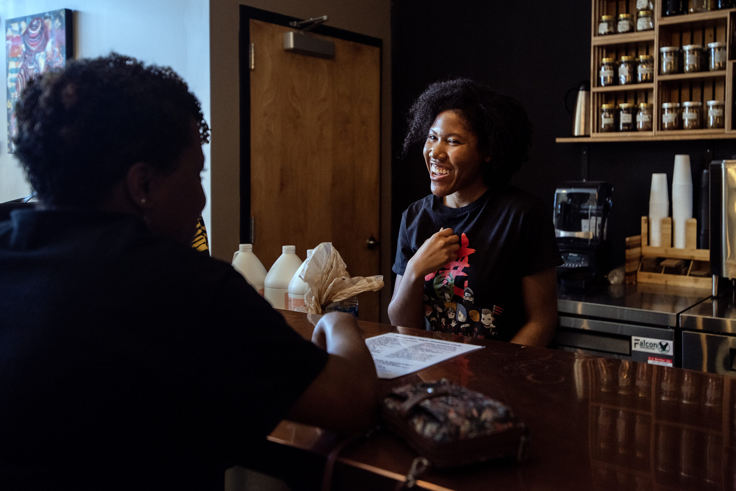 An employee smiles as she speaks to customers from behind the bar.