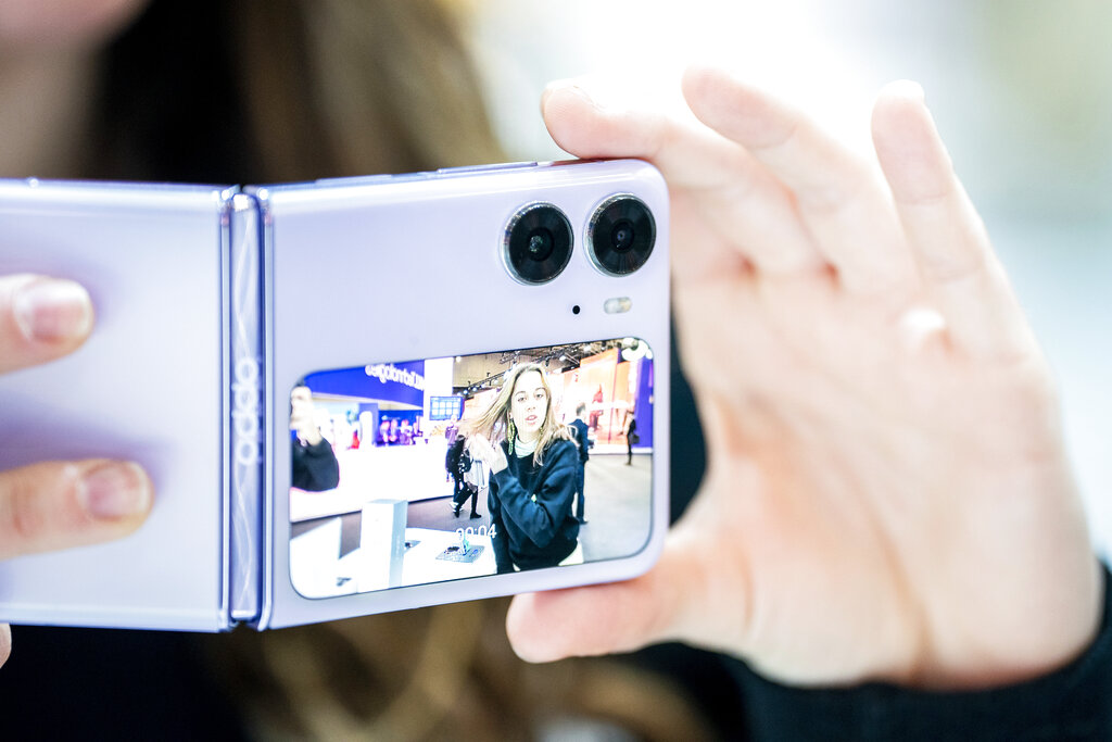 Oppo workers test Oppo Find N2 Flip smartphone camera during the Mobile World Congress 2023 in Barcelona, Spain, on Wednesday, March 1, 2023