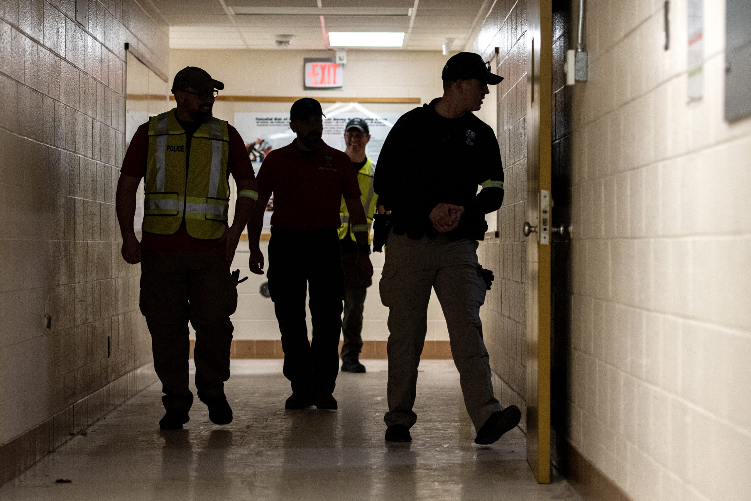 The silhouette of four officers in a school hallway as a training exercise takes place.