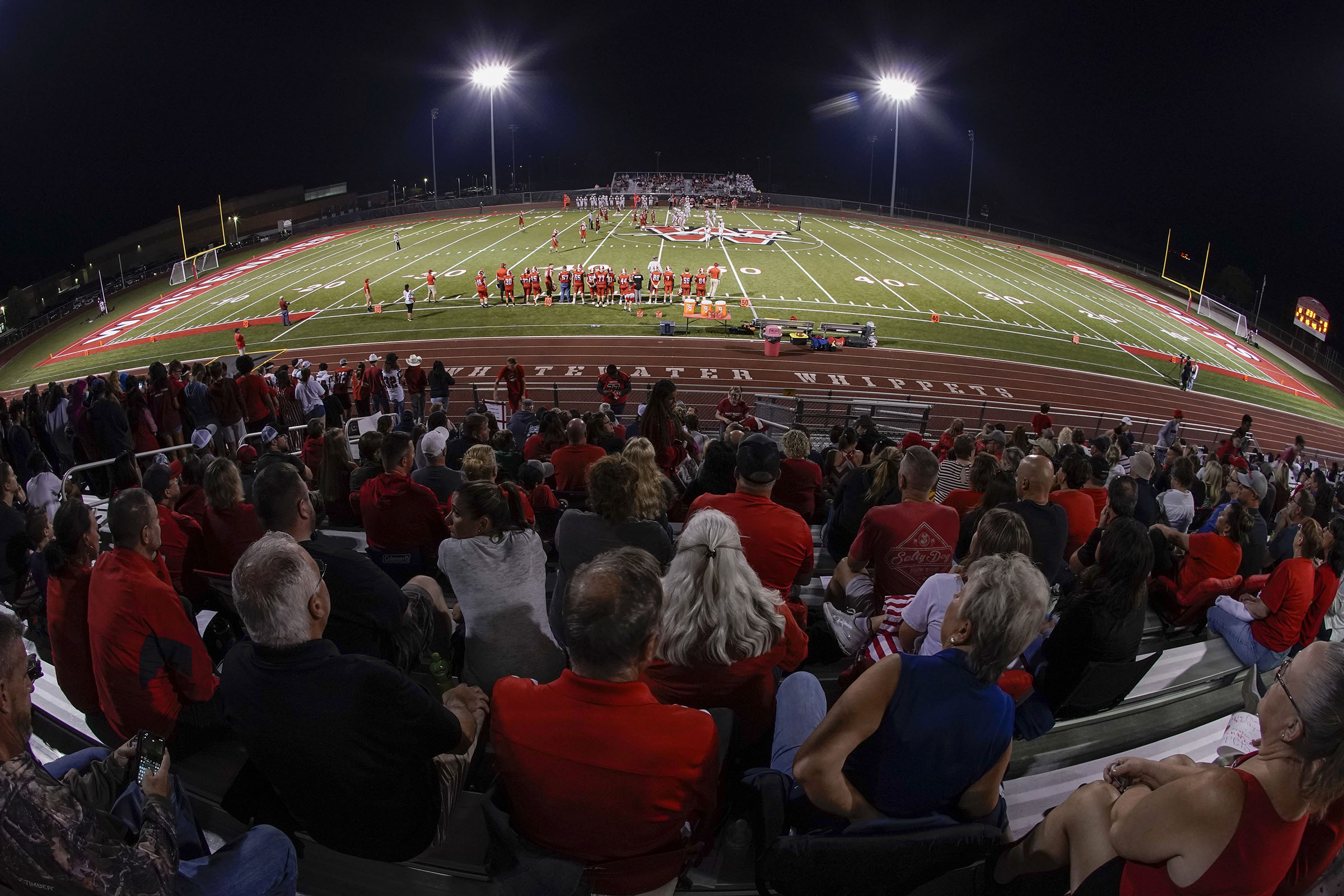 Fans sit in the stands at a high school football game