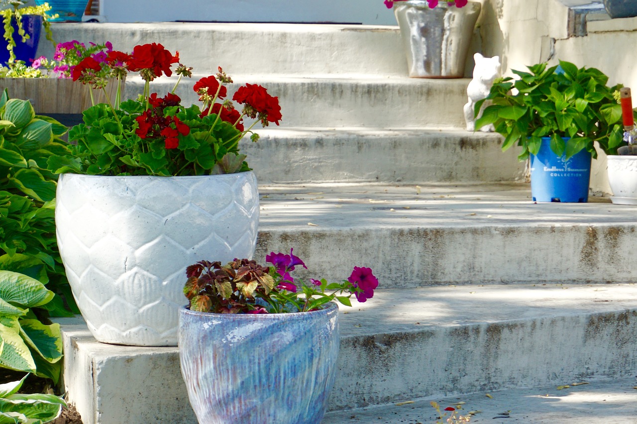 Containers with flowers sitting on steps.