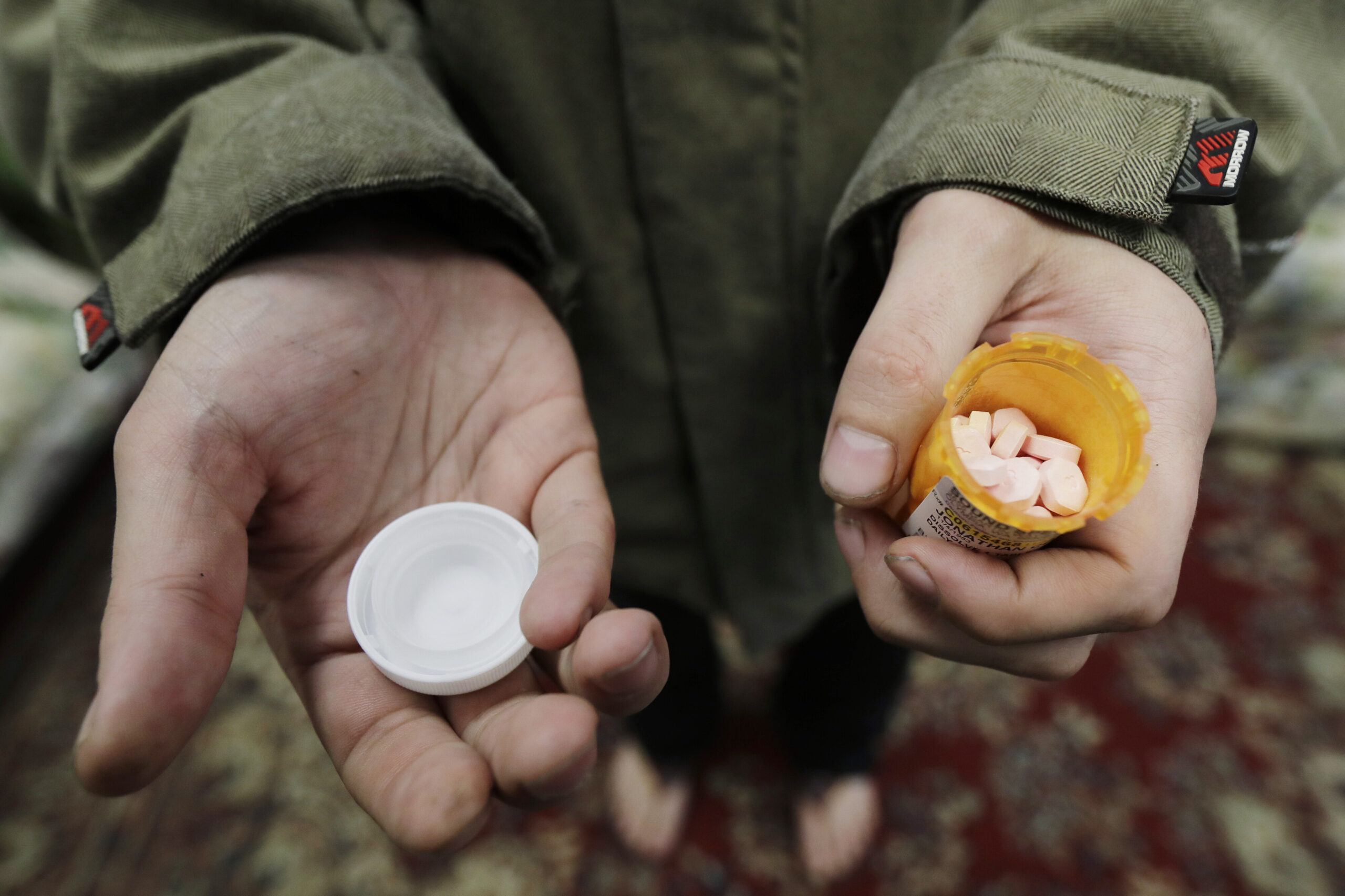 In this Nov. 14, 2019, photo, Jon Combes holds his bottle of buprenorphine, a medicine that prevents withdrawal sickness in people trying to stop using opiates, as he prepares to take a dose in a clinic in Olympia, Wash. The U.S. Department of Justice made clear, Tuesday, April 2, 2022, that barring the use of medication treatment for opioid abuse is a violation of federal law. Ted S. Warren/AP Photo