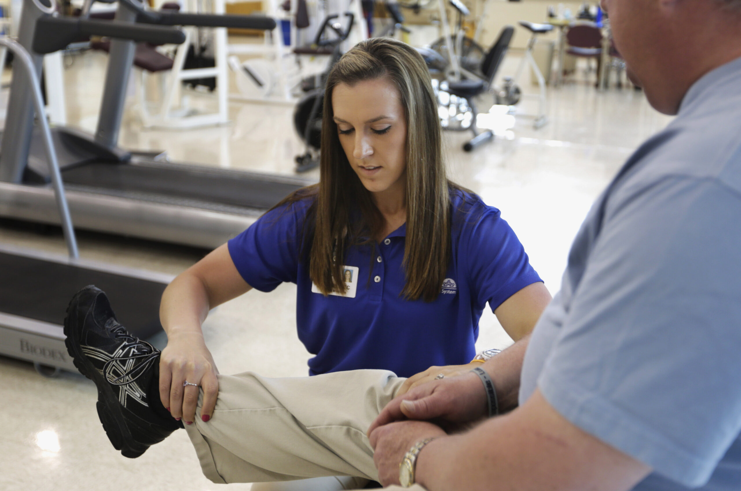 A physical therapist holds the knee of her patient.