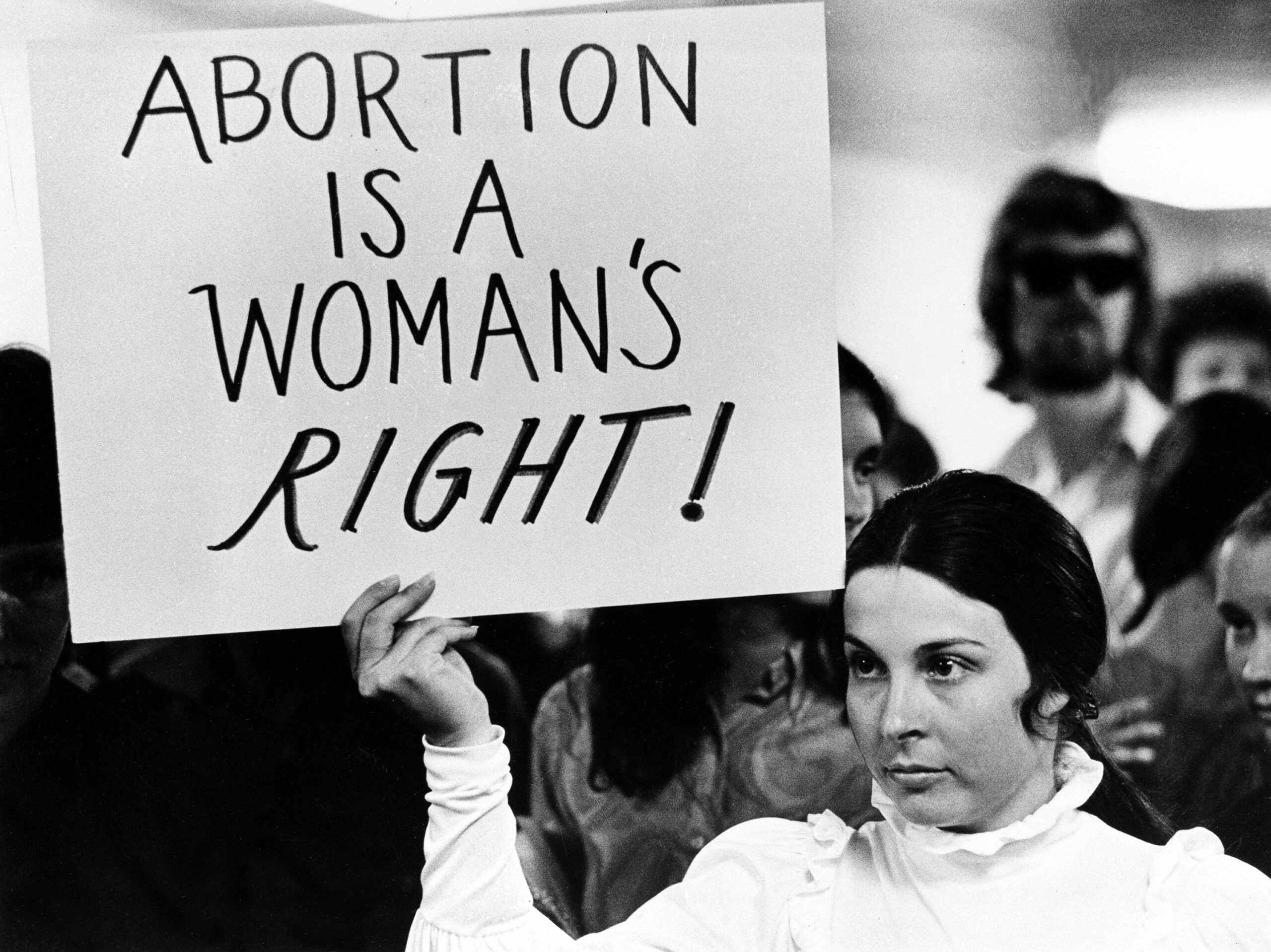A young woman holds a sign demanding a woman's right to abortion at a demonstration to protest the closing of a Madison abortion clinic in Madison, Wis., April 20, 1971