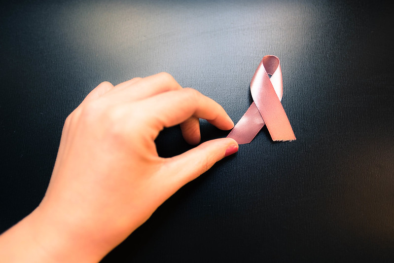 Hand holding breast cancer awareness ribbon
