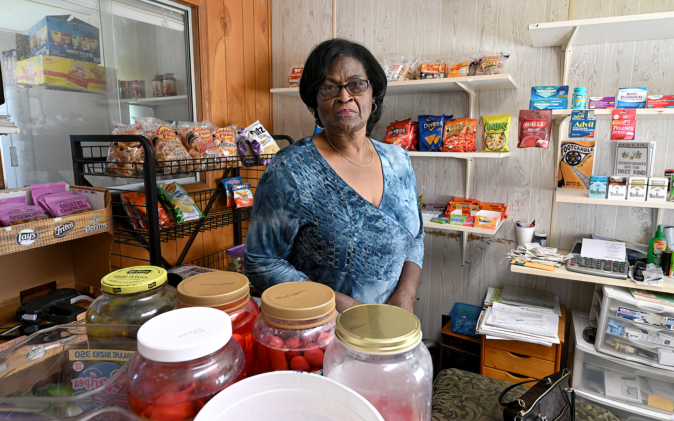 Dorothy Oliver stands behind the counter of the convenience store she runs in Alabama