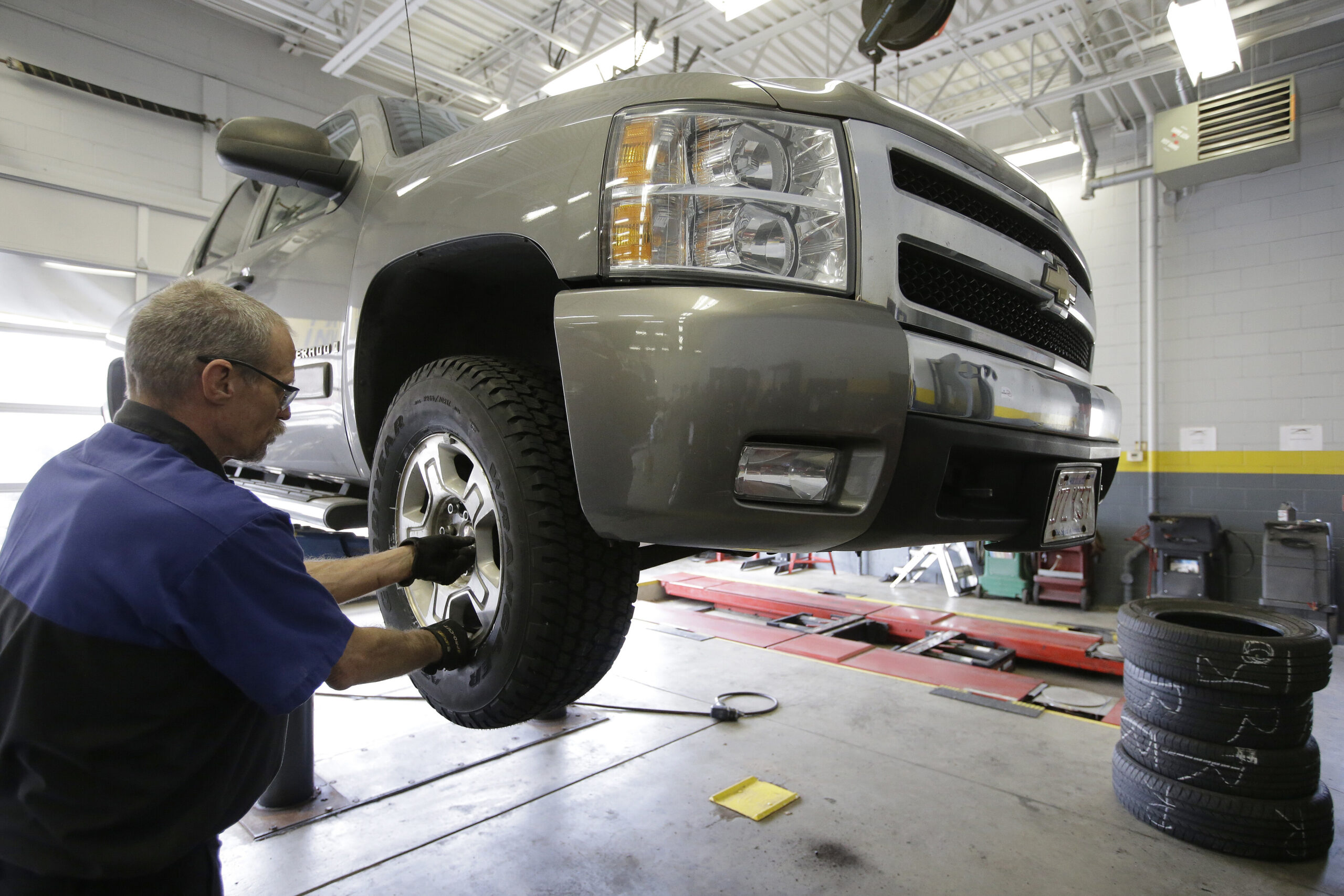 Maintenance technician Paul Bourque, of Everett, Mass., installs a wheel with a new tire on a vehicle at a Goodyear Auto Service Center
