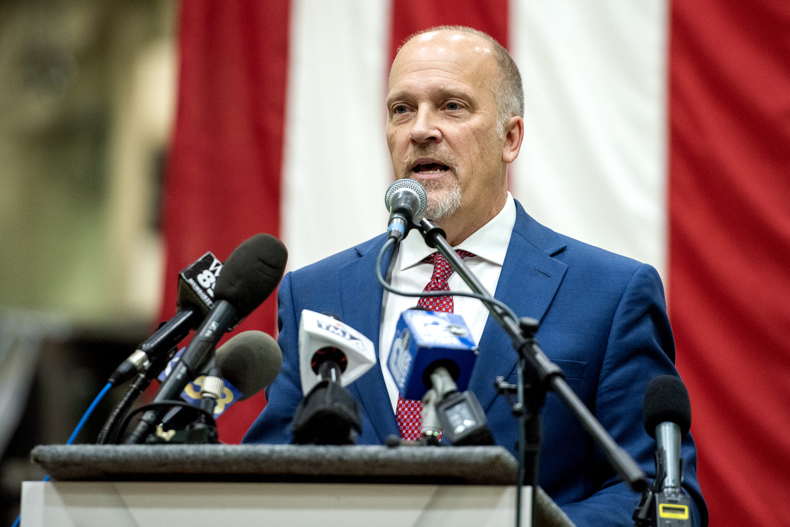 A vertical US Flag is seen behind Brad Schimel as he speaks.