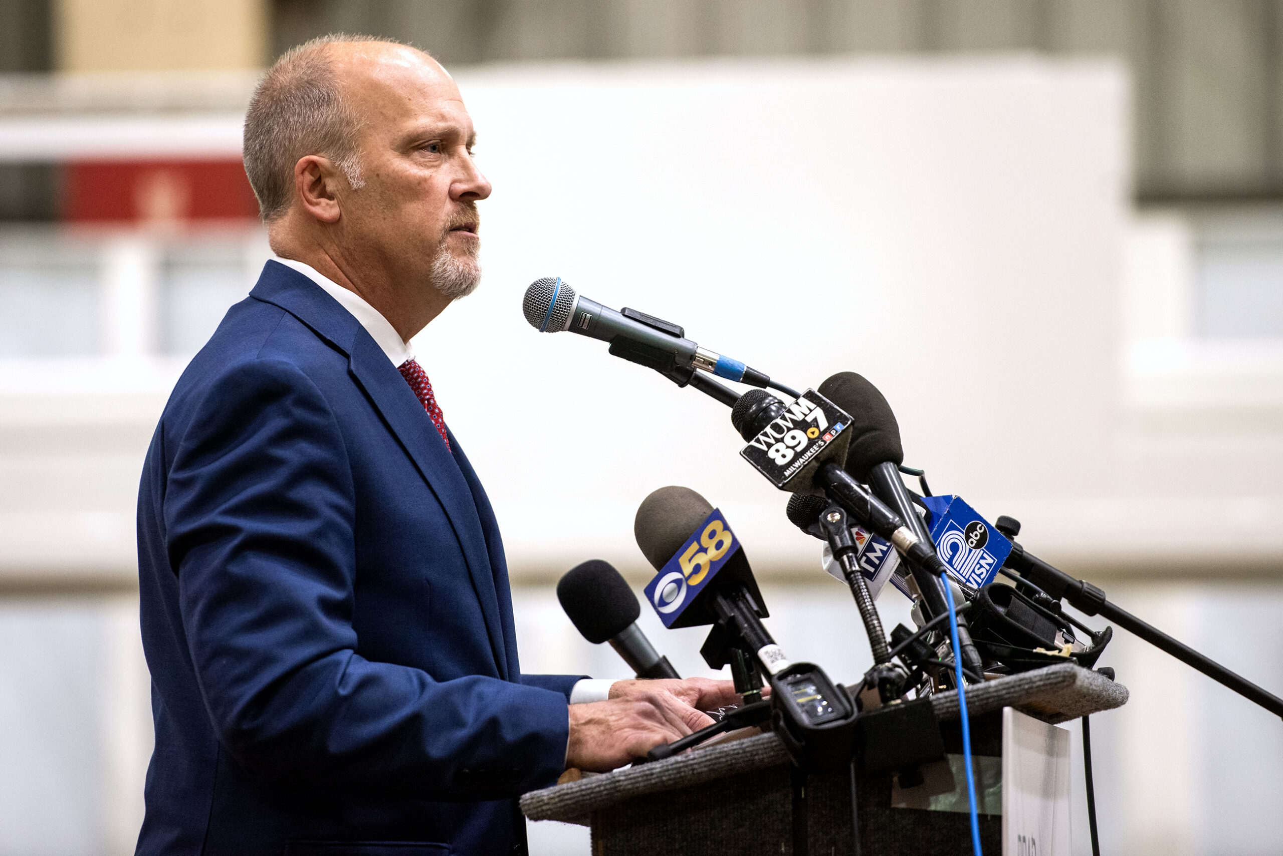 Brad Schimel stands in front of microphones at a podium.