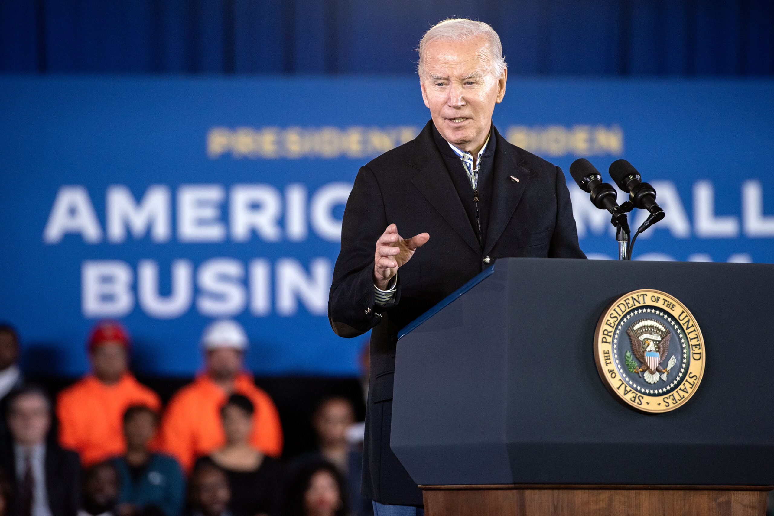 Biden gestures as he speaks from behind a podium.