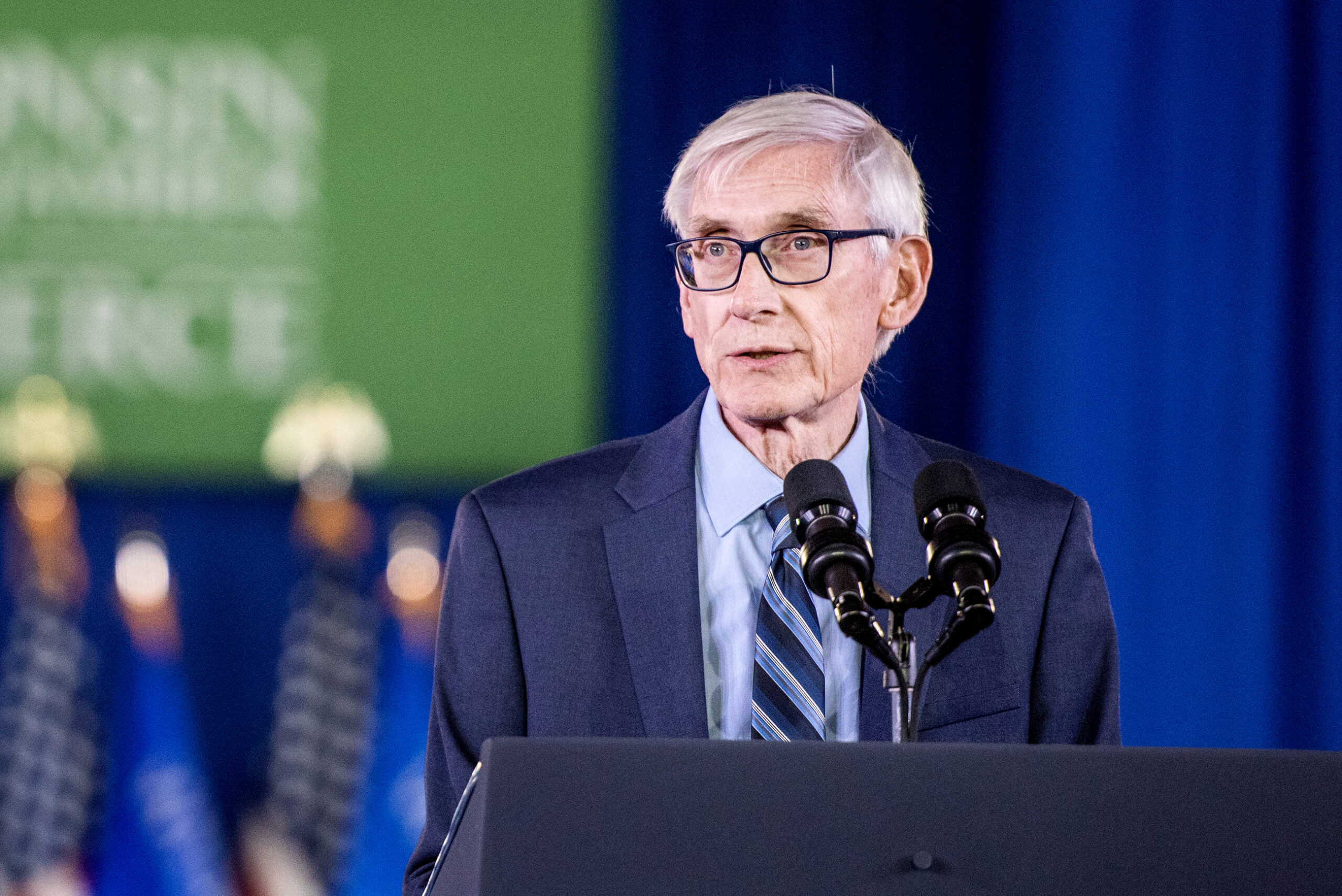 Evers speaks at a podium.