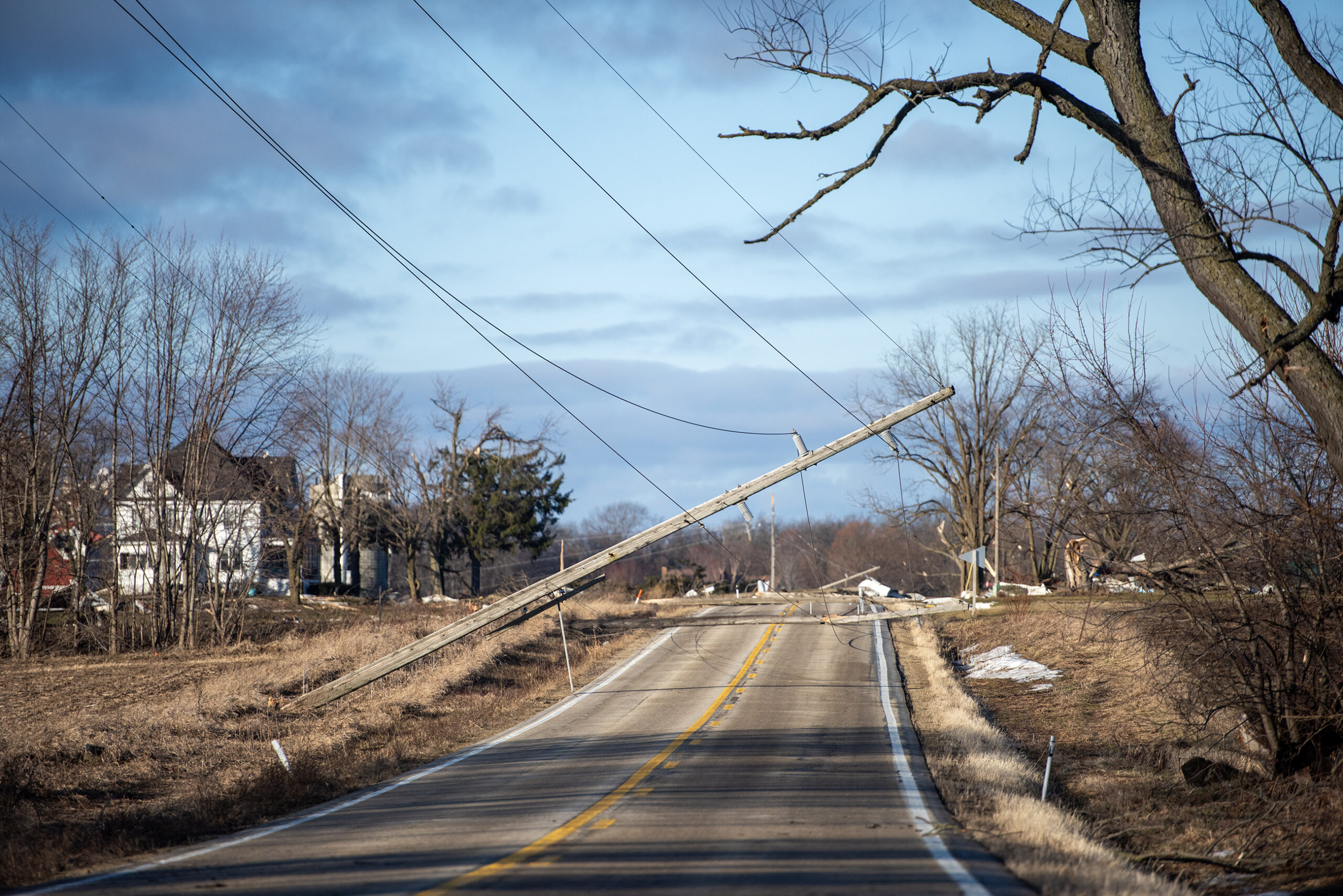 A pole with power lines hangs over the road after a storm went through the area.