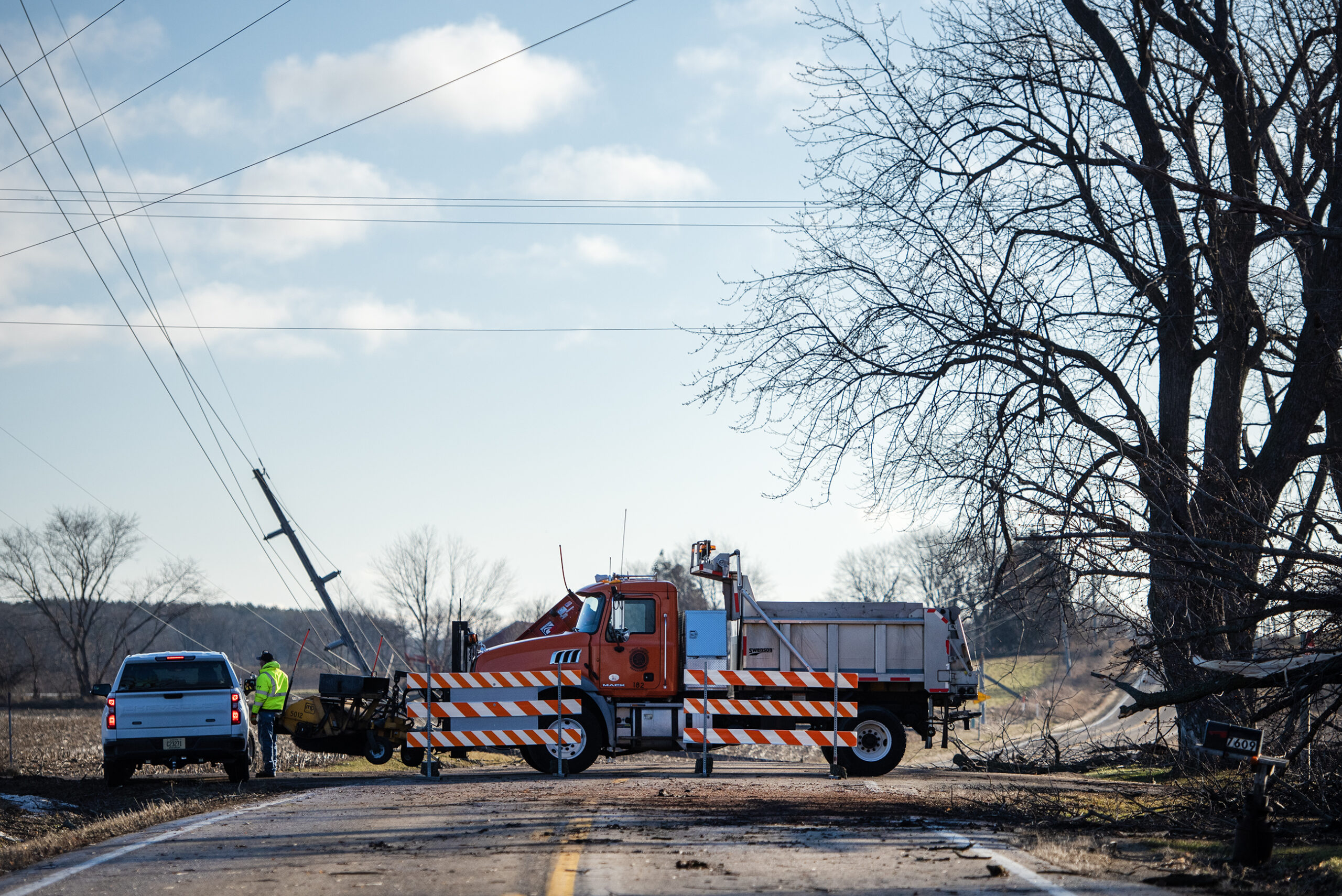 A large truck and barricades block off a road in rural Edgerton, Wis.