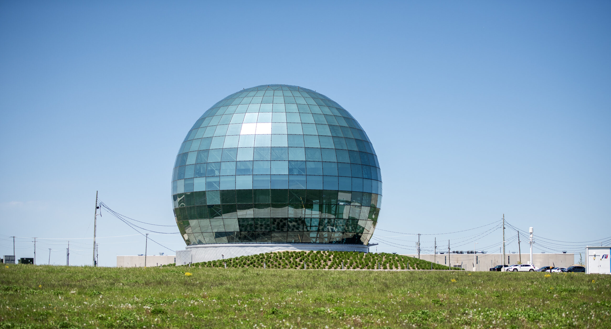 A round glass globe structure can be seen on a sunny day.