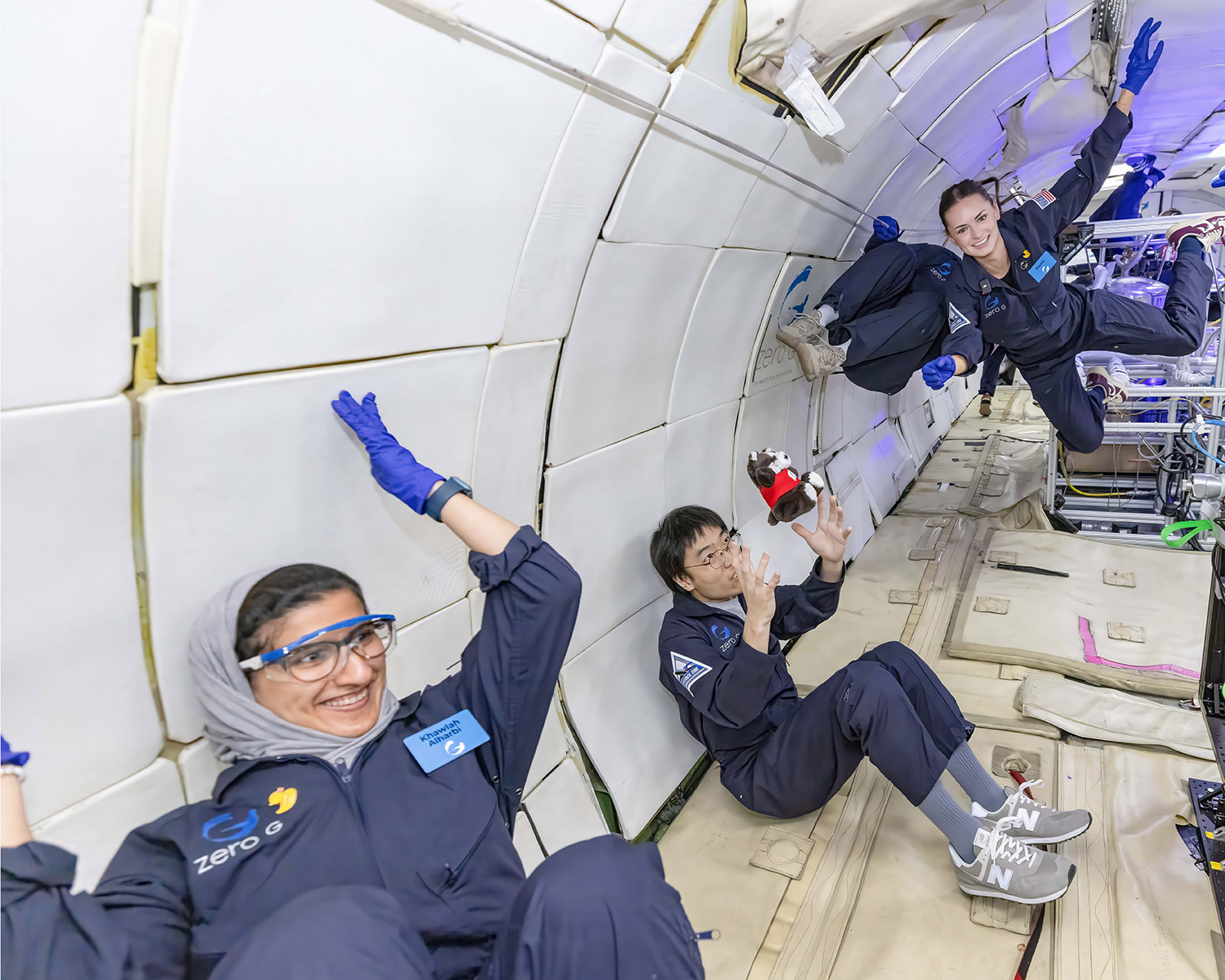 UW-Madison Ph.D. students Khawlah Ahmad Alharbi (left), Xuepeng Jiang (center) and Rayne Wolf (right) experience weightlessness on G-Force One prior to testing their 3D printer in zero-gravity.