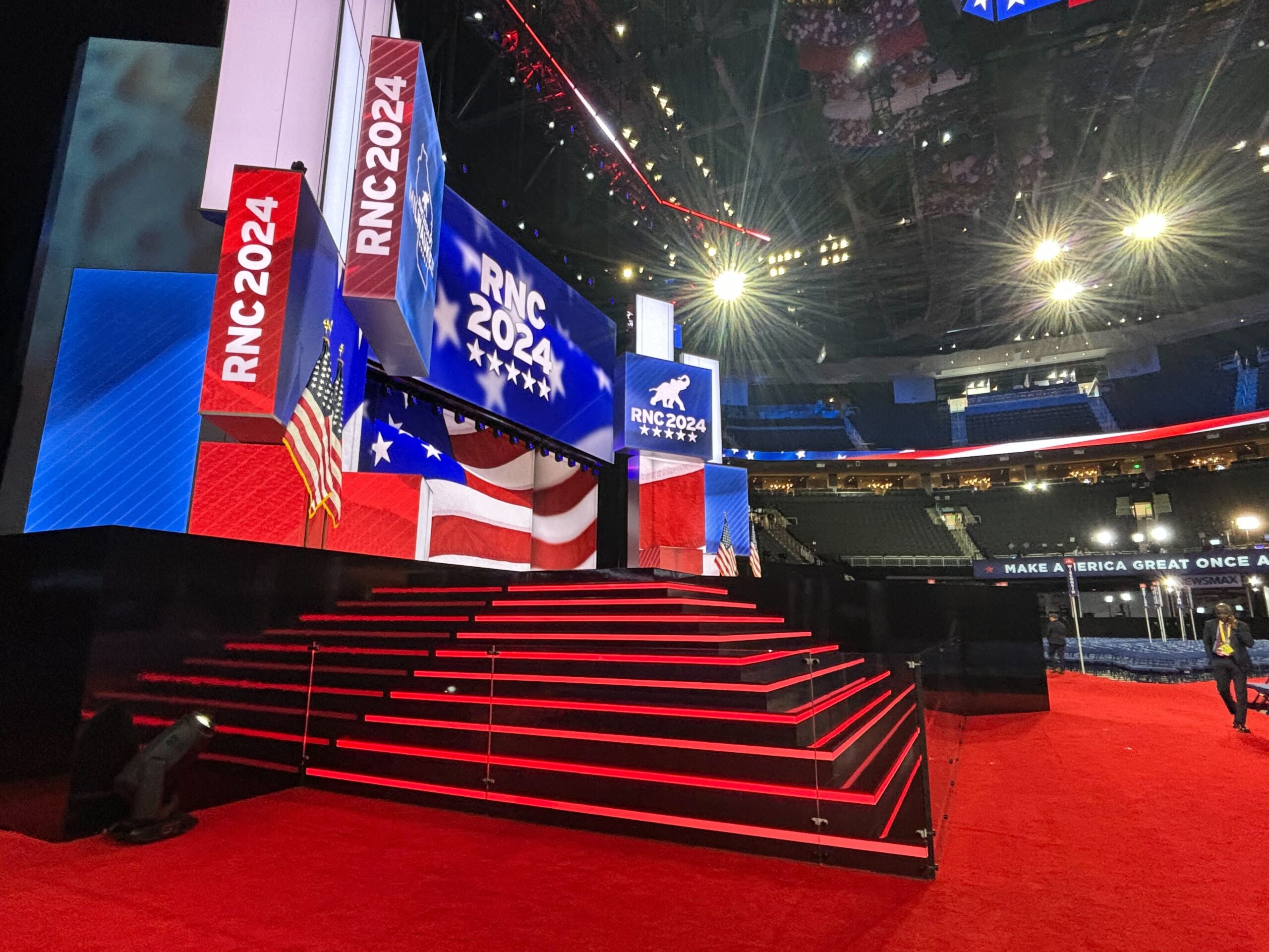 Red, white and blue signs saying "RNC 2024" surround a stage with red stairs.